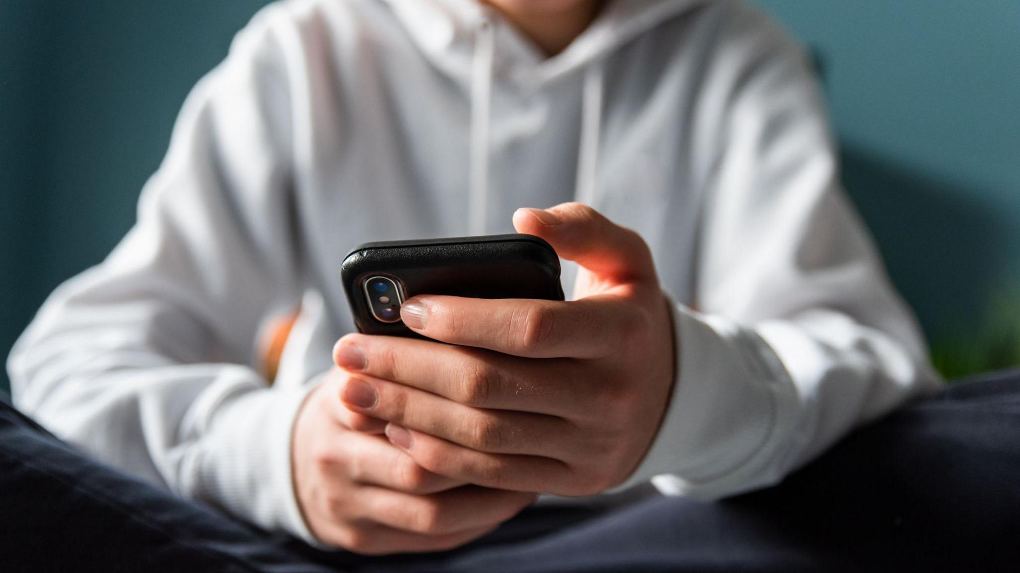 A teenage boy using a phone