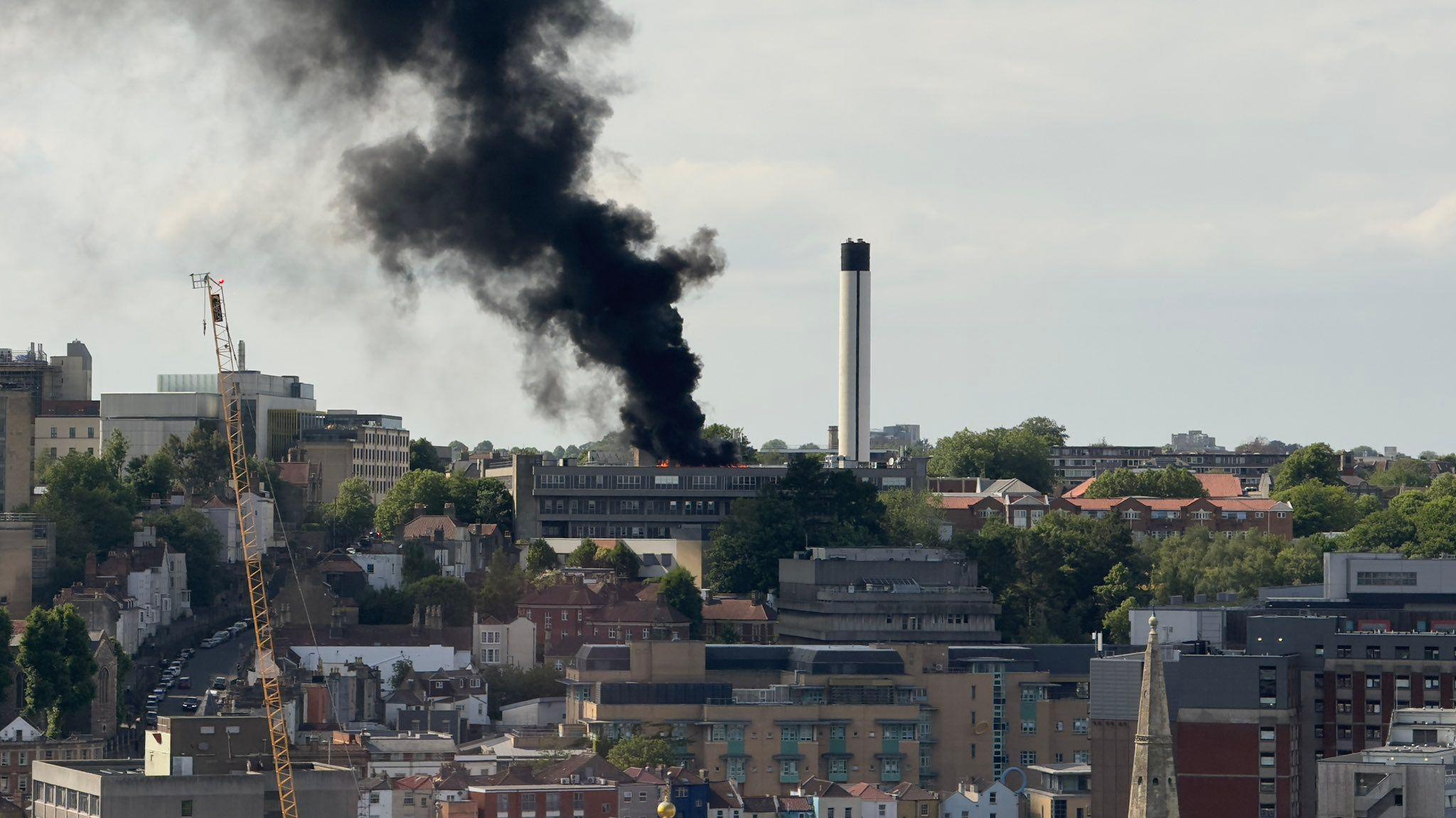 A skyline shot of Bristol showing the fire at St Michael's Hospital. A thick black smoke plume can be seen coming from the roof of the building. The Cotham area of the city can be seen in the distance.
