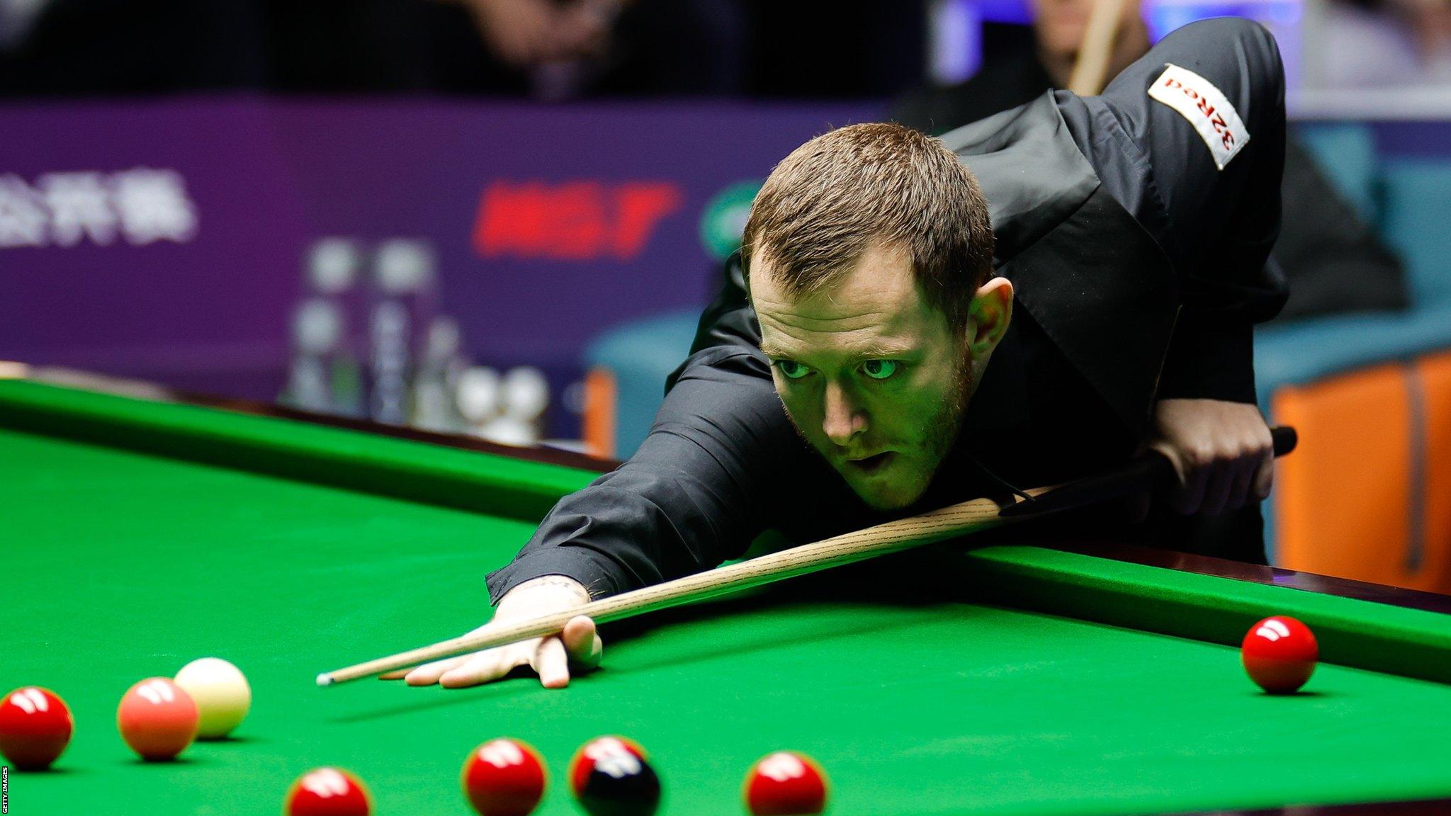 Mark Allen hits a shot in the in 2023 Champion of Champions final against Judd Trump