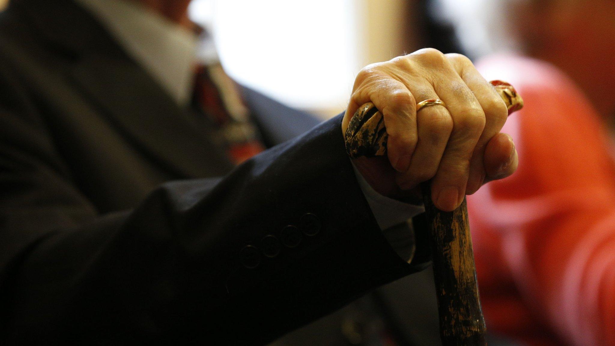 Elderly man holding walking stick