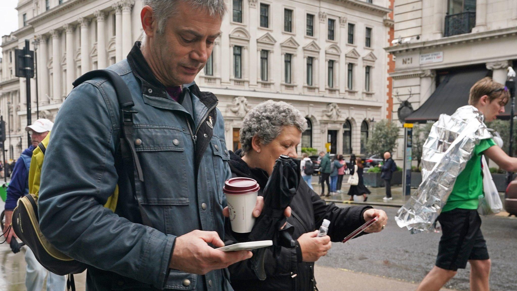 Members of the public looking at their mobile phones after the test alert on Regent Street in London