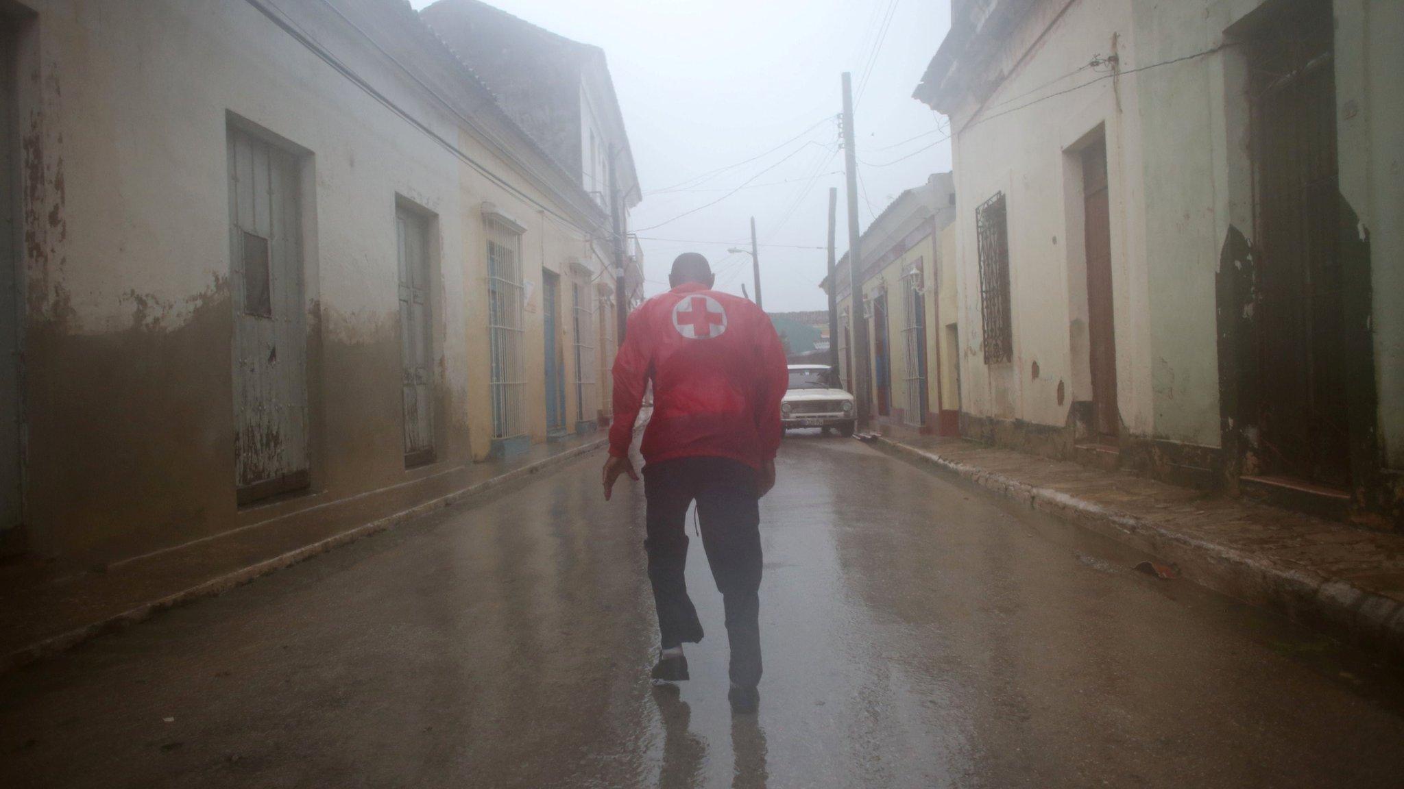 Civil defence officer runs down a street in Remedios, Cuba