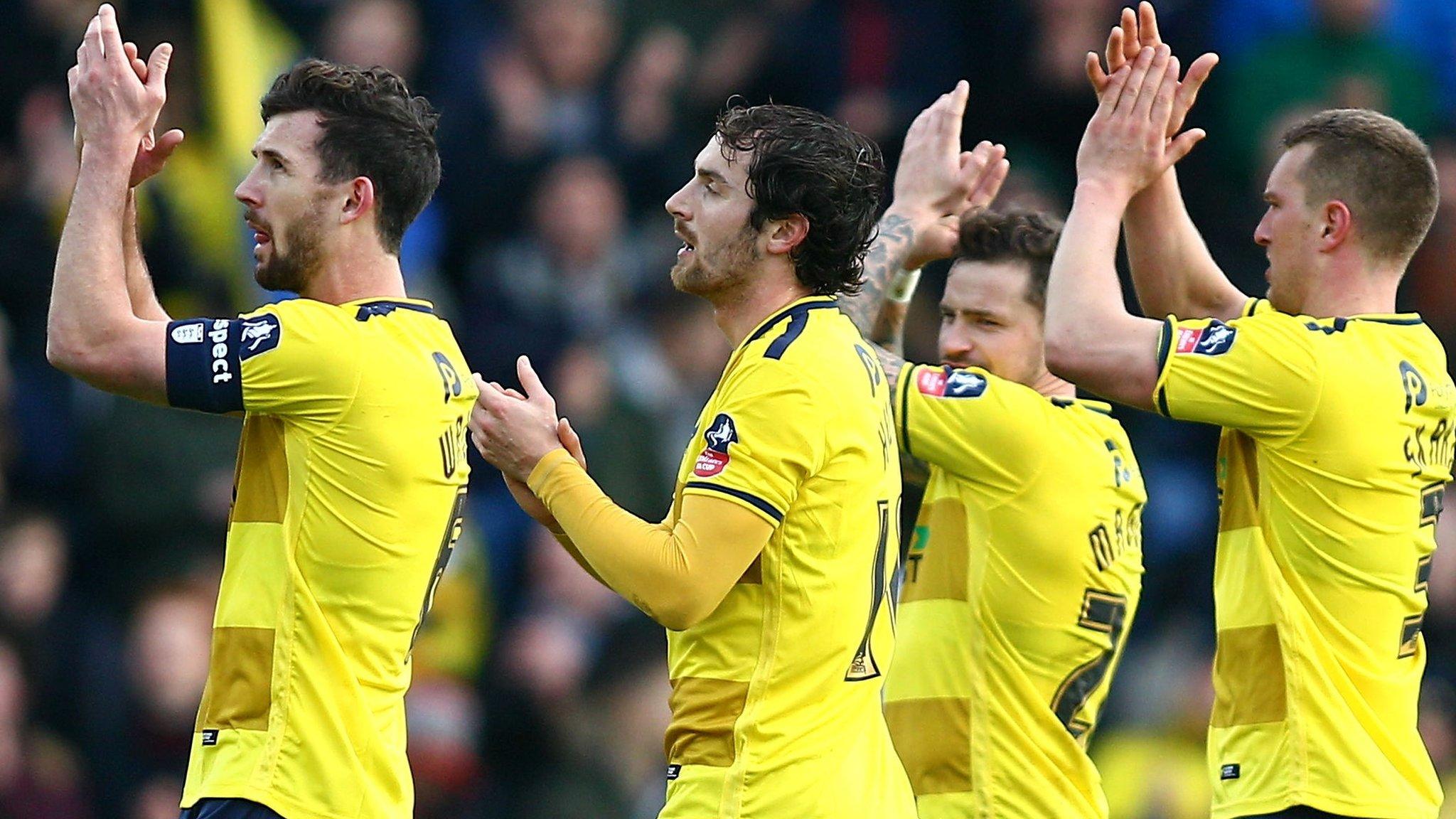 Oxford United players celebrate beating Swansea