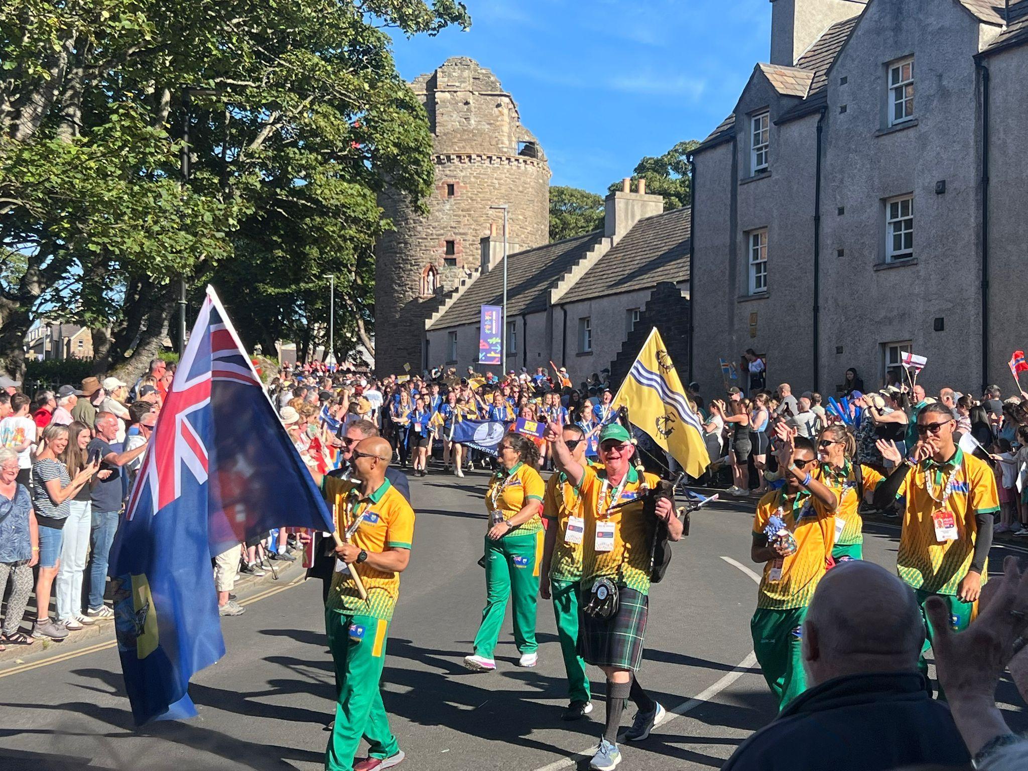 Group of competitors walking down the street with different colourful flags in hand