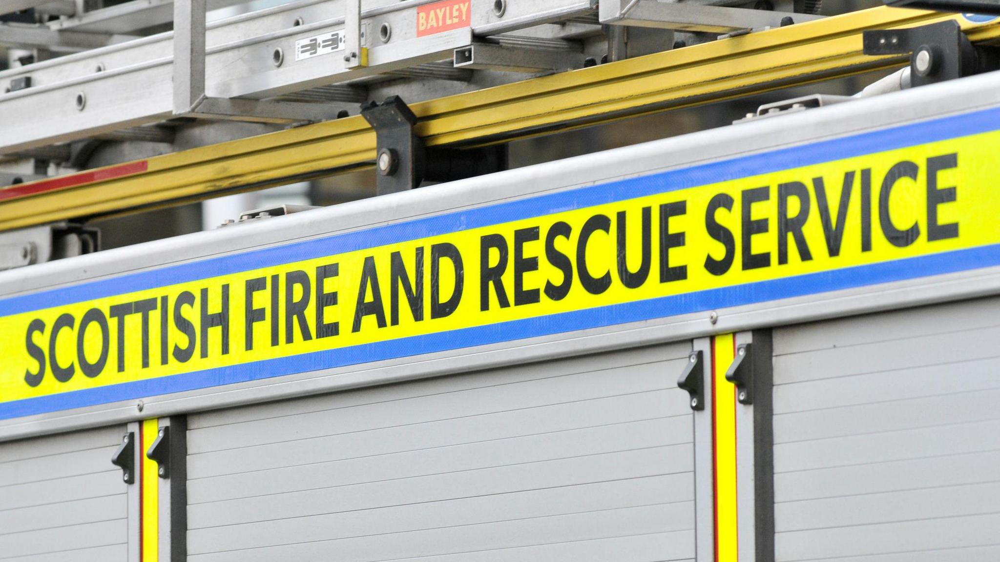 The side of a fire engine with the Scottish and Fire Service logo on it