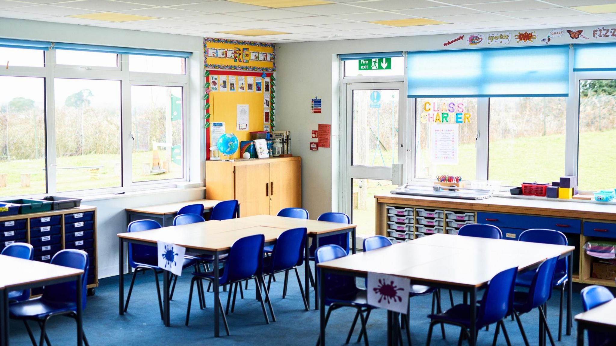 A generic primary school classroom with playing fields and/or fields outside 