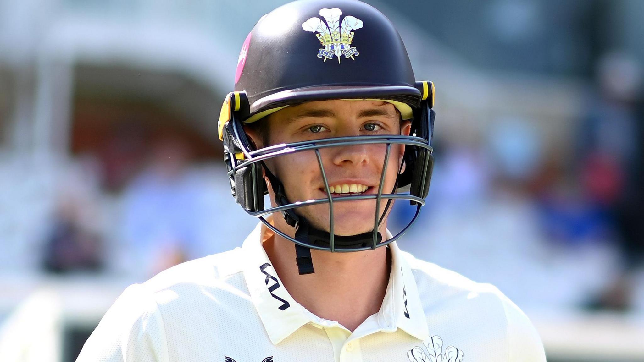 Jamie Smith smiles while wearing a helmet