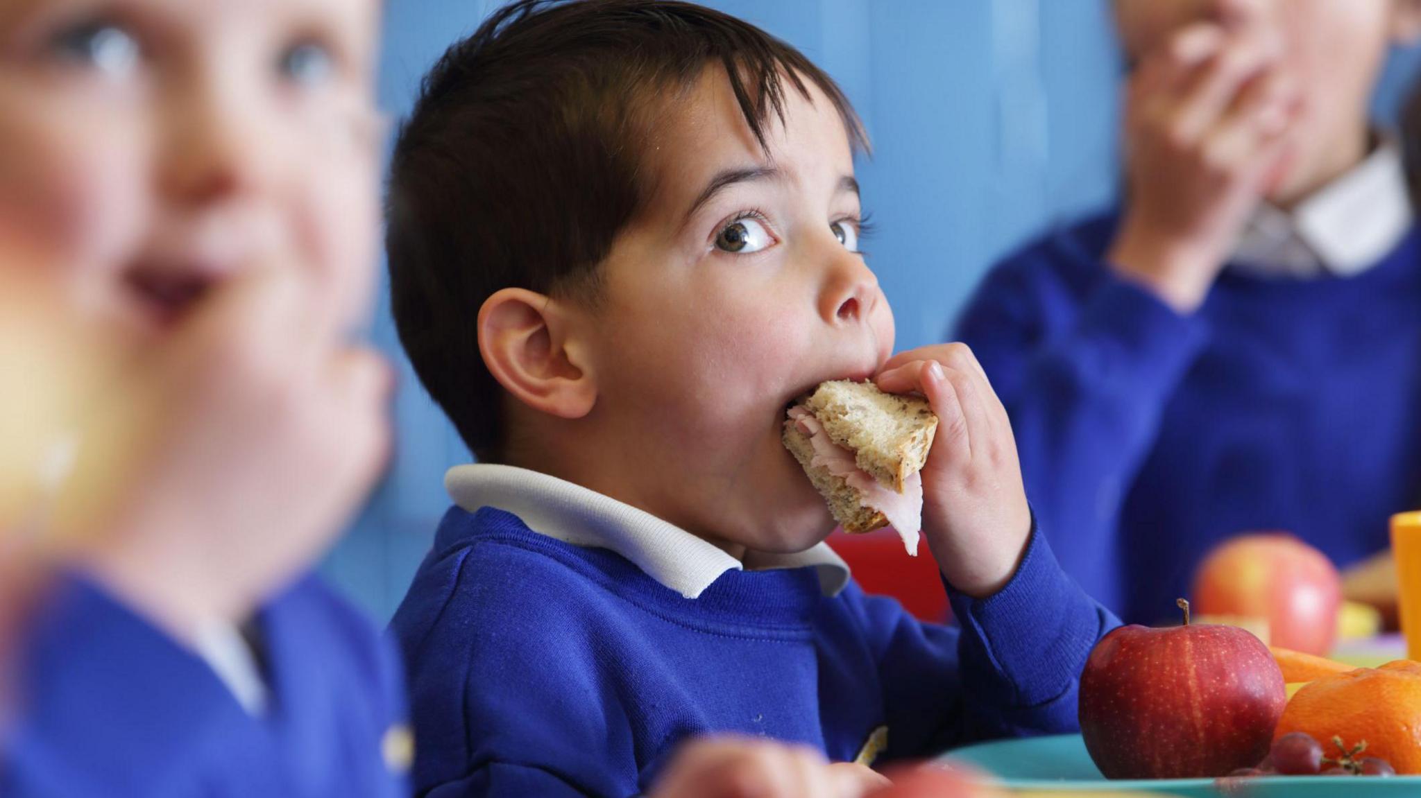 A boy eating a sandwich.