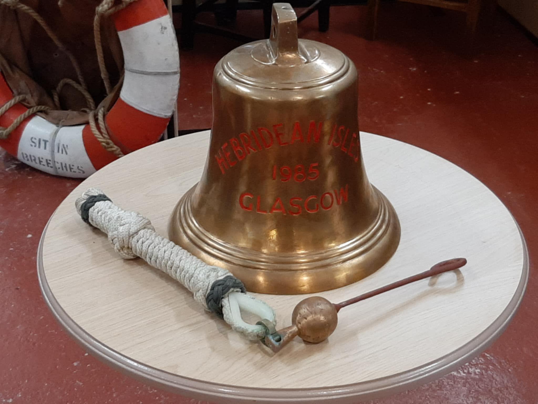 Hebridean Isles bell on display on a circular wooden table