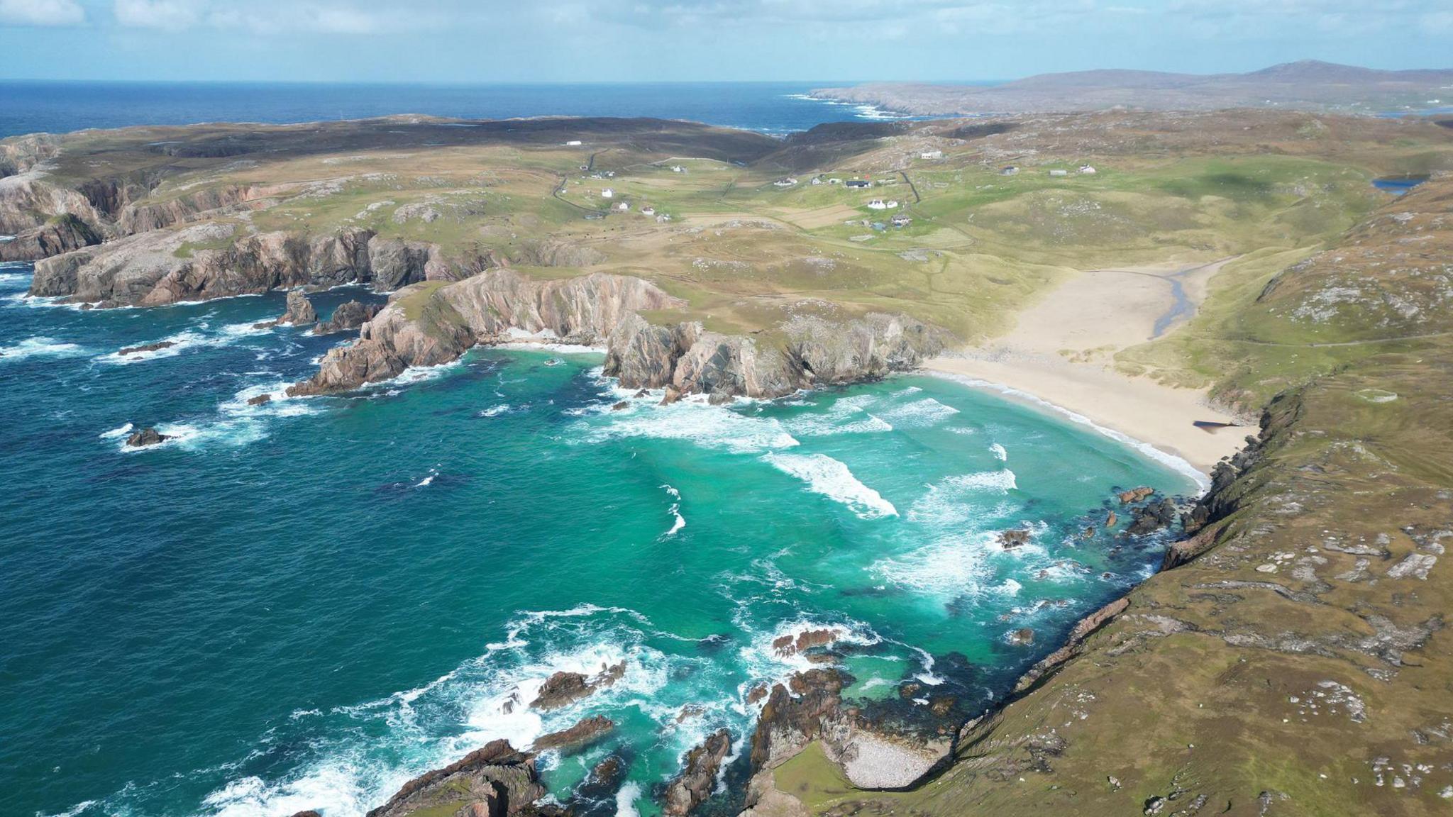 Tràigh ghainmich bhon adhar le taighean agus bailtean