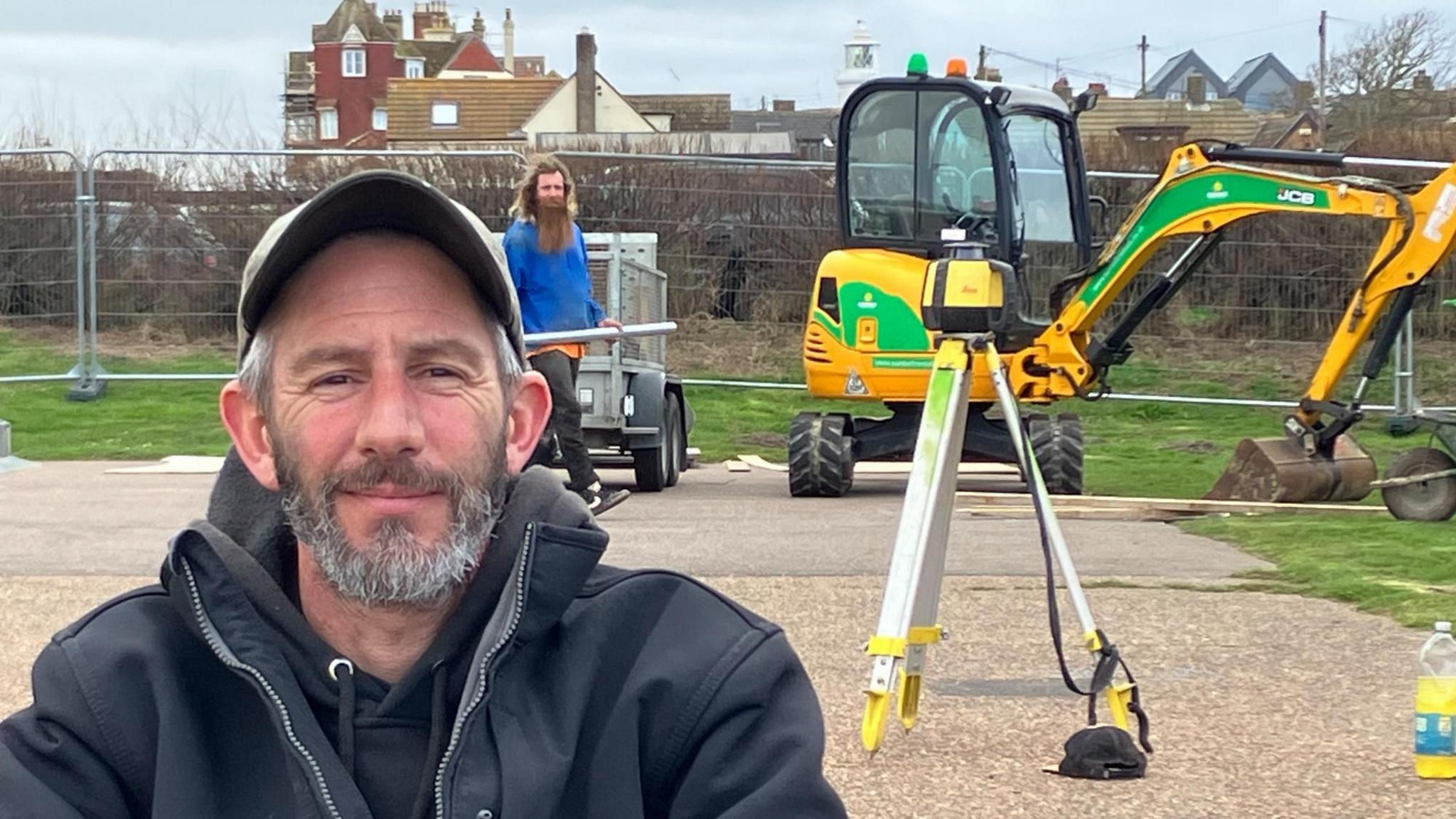 Carl Hurr at Southwold's skatepark with  digger and the town's lighthouse in the background