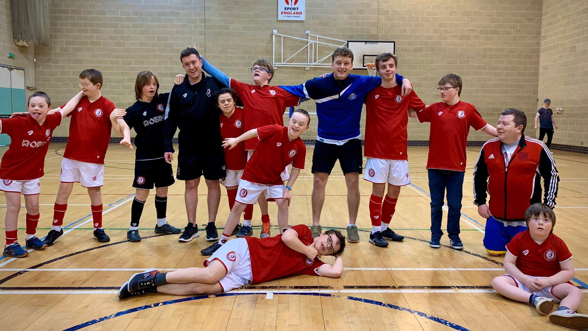 Bristol Down Syndrome Football Club players pose for a photo on an indoor pitch