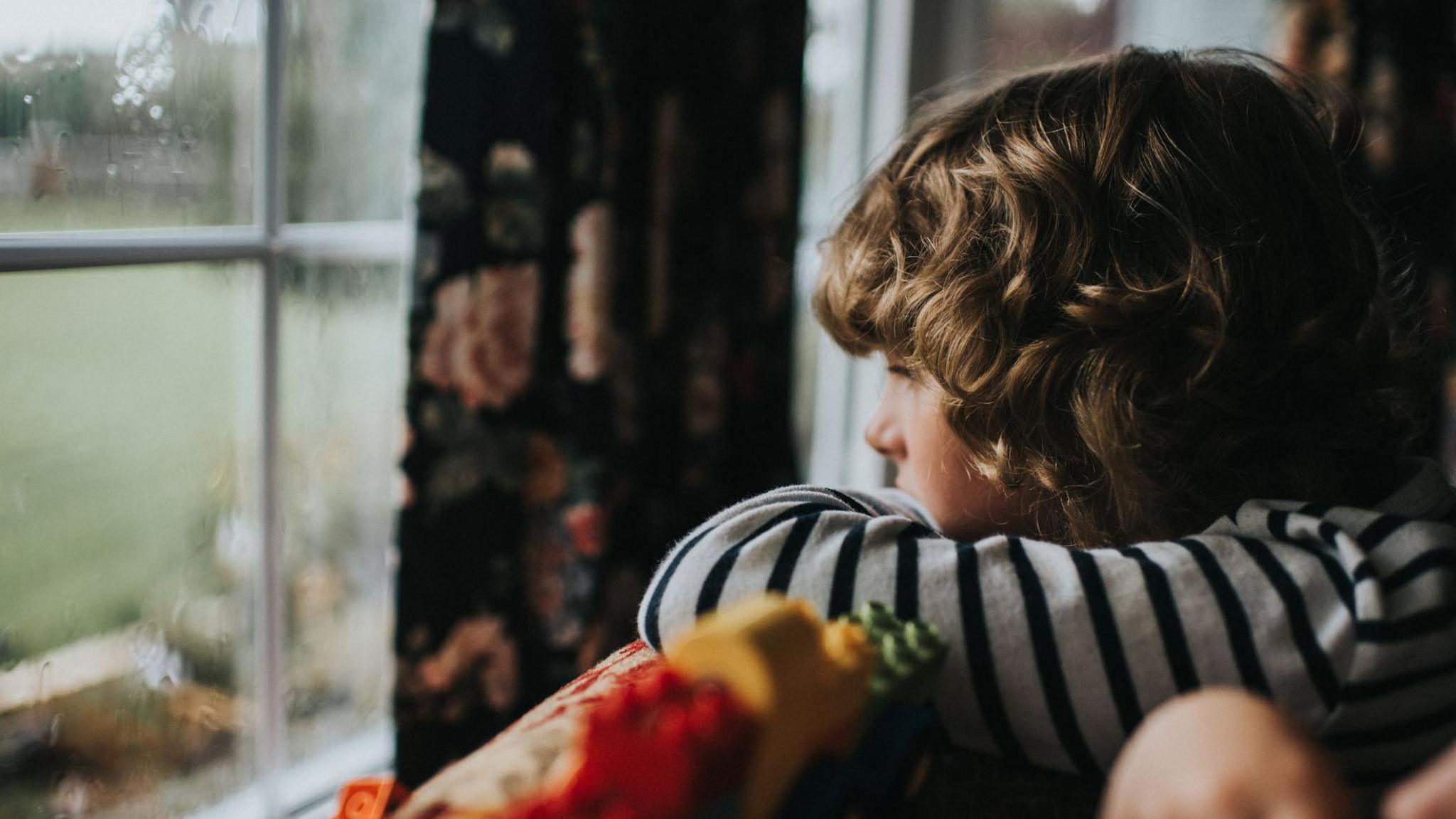 Boy looking outside window