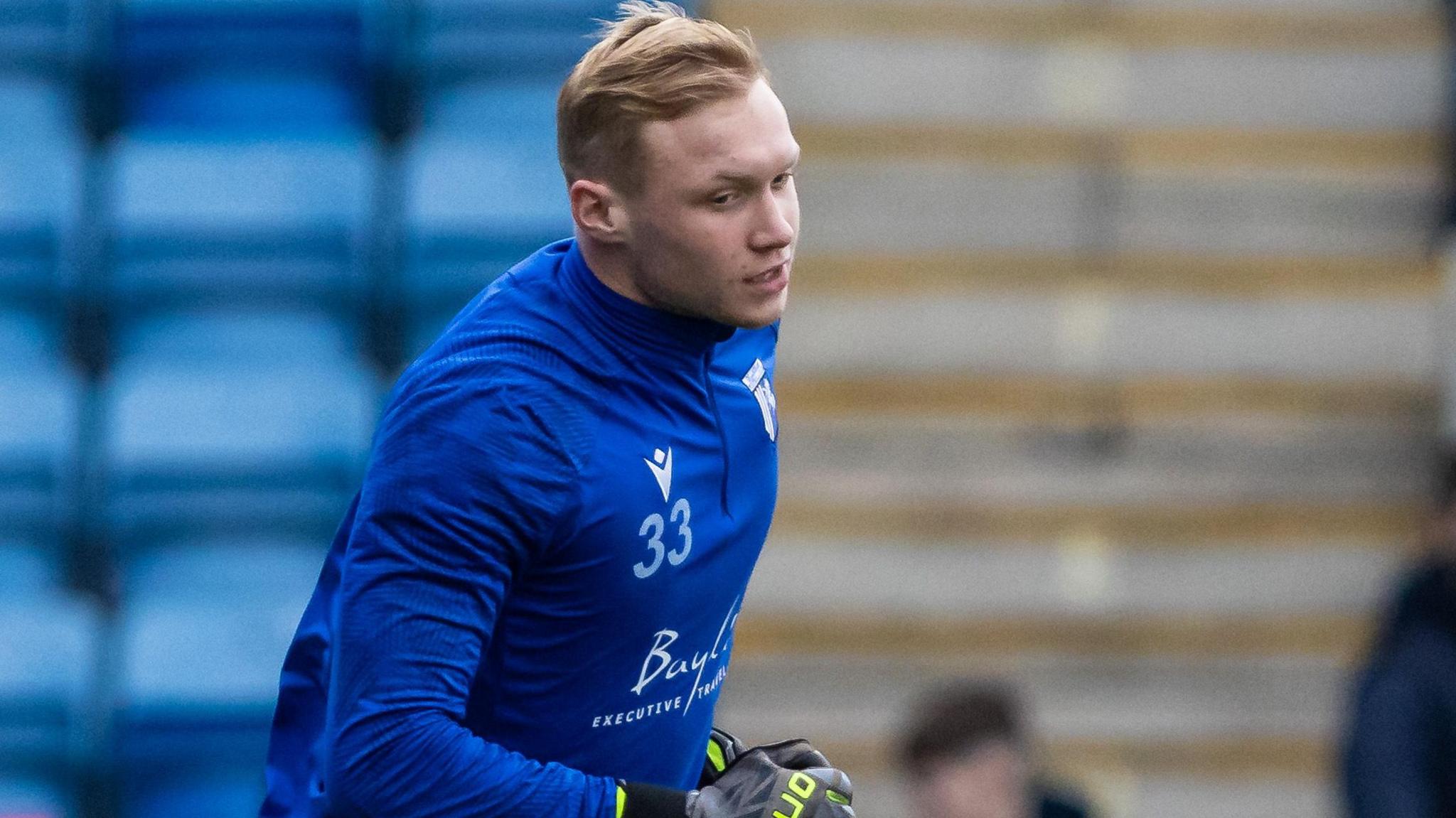 Taite Holtam runs while warming up for Gillingham