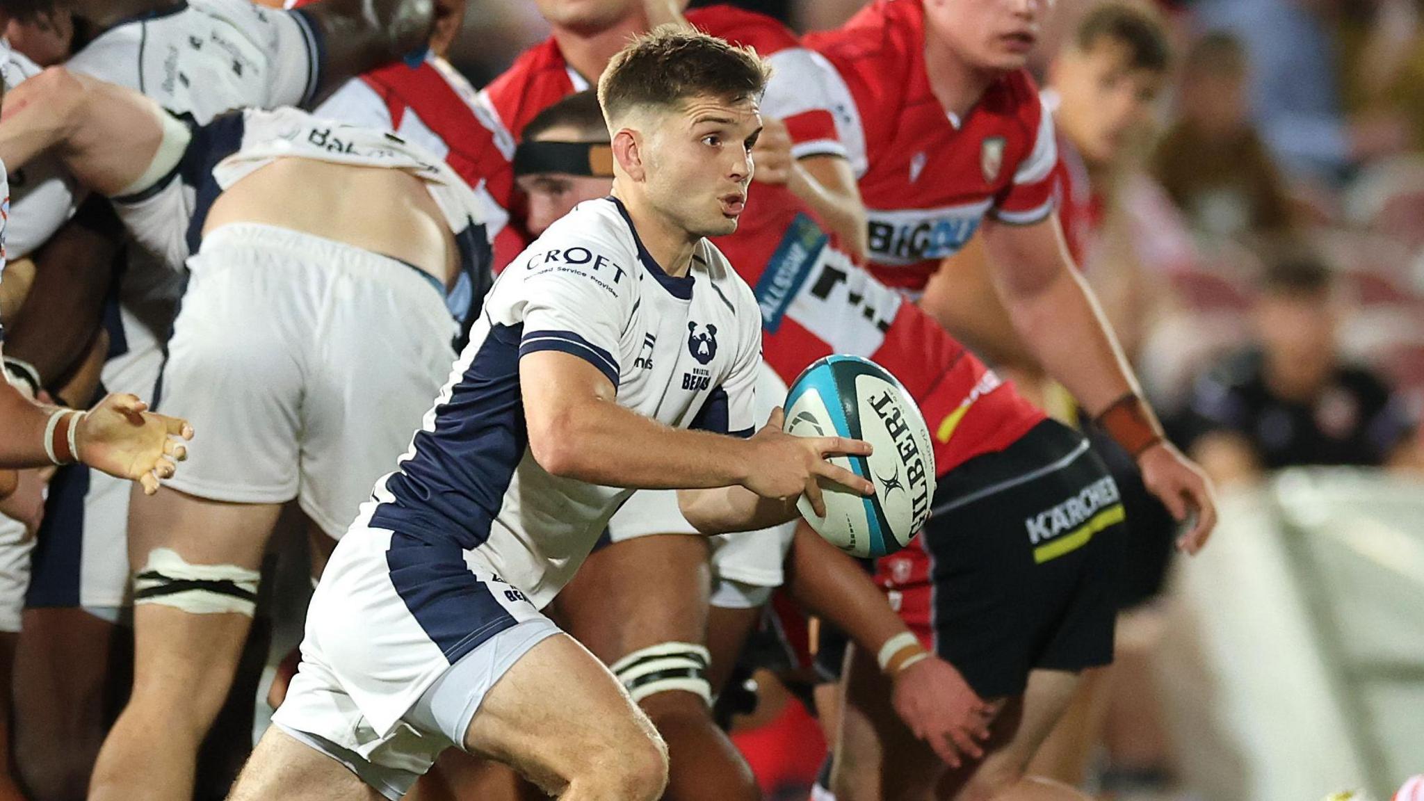 Harry Randall runs with the ball in his hands as Bristol and Gloucester players maul behind him during a Prem Cup match