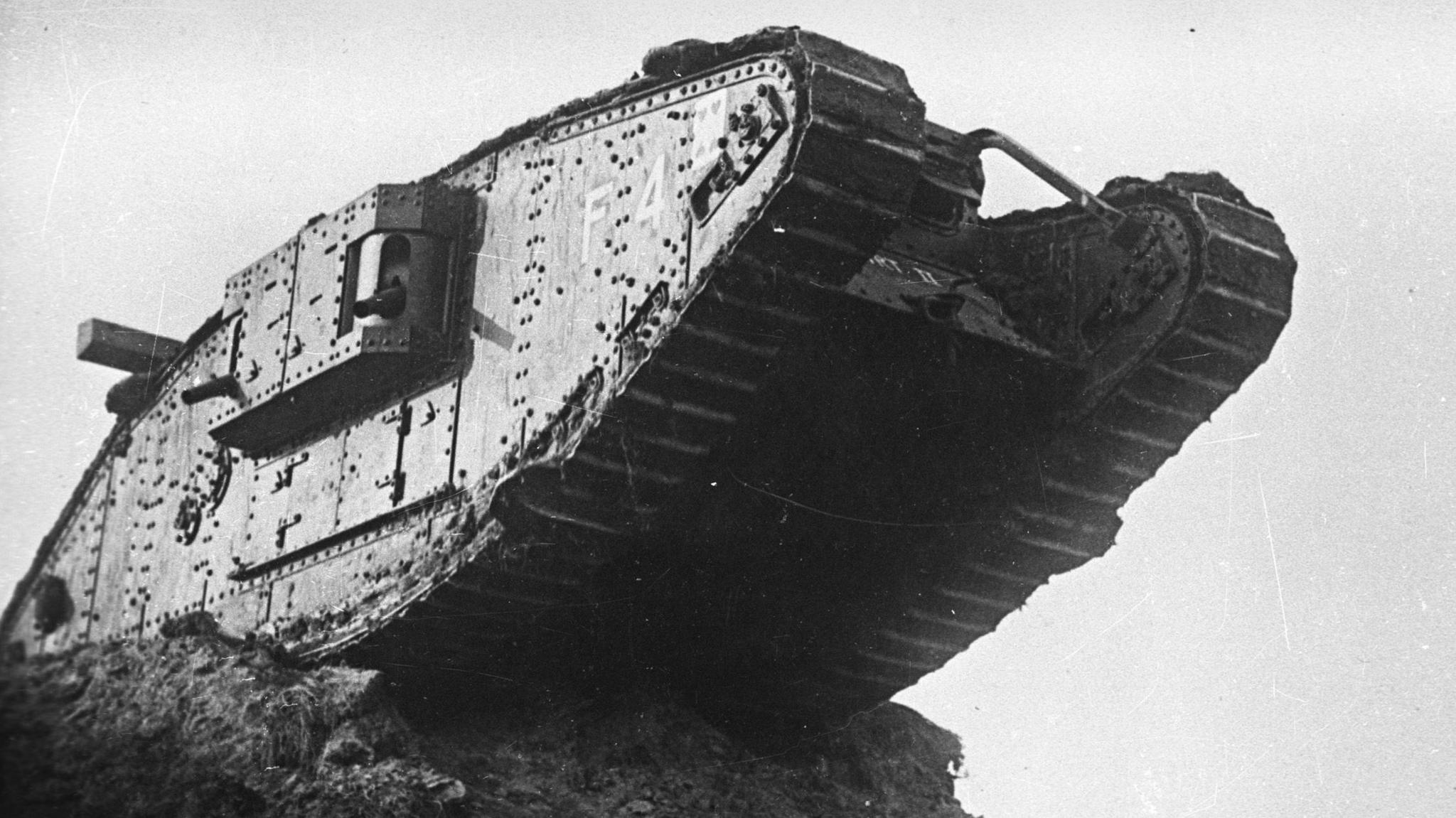 Black and white photo of a Mark IV tank, which stands on the edge of a precipice with half of the vehicle hanging over the edge in mid-air.
