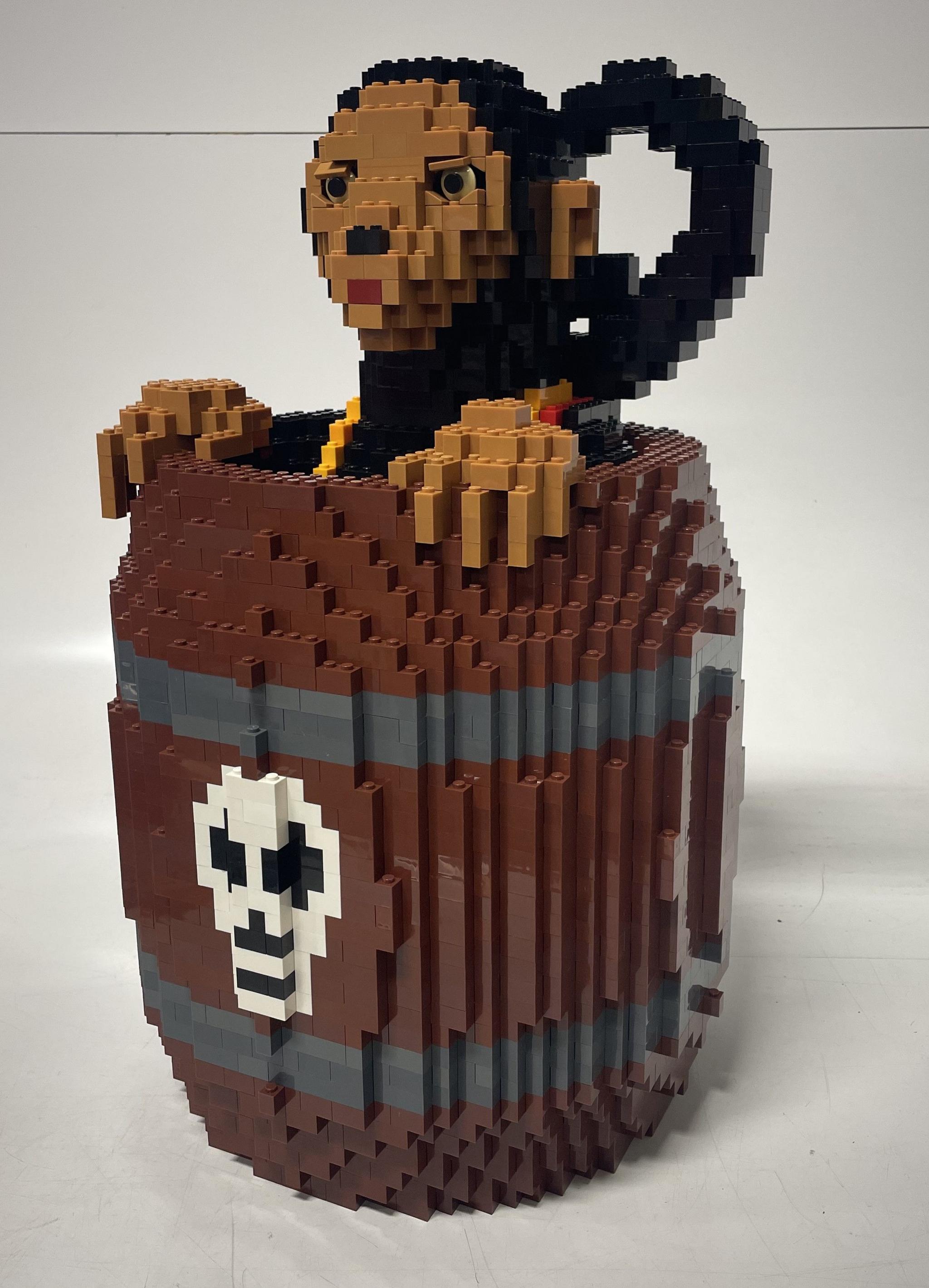 A brick model of a monkey in a barrell. 