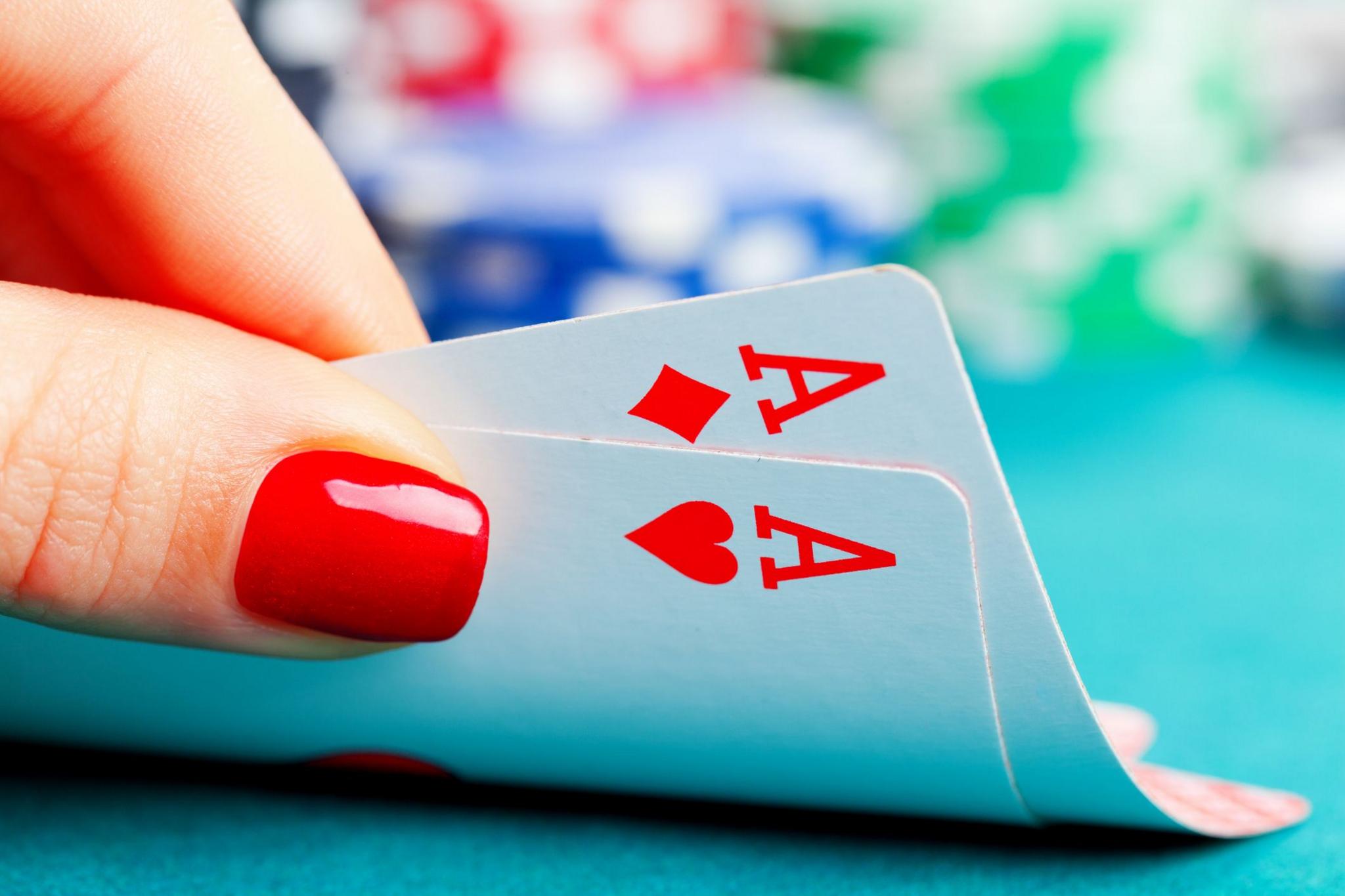 A woman reveals two Aces in her hand.