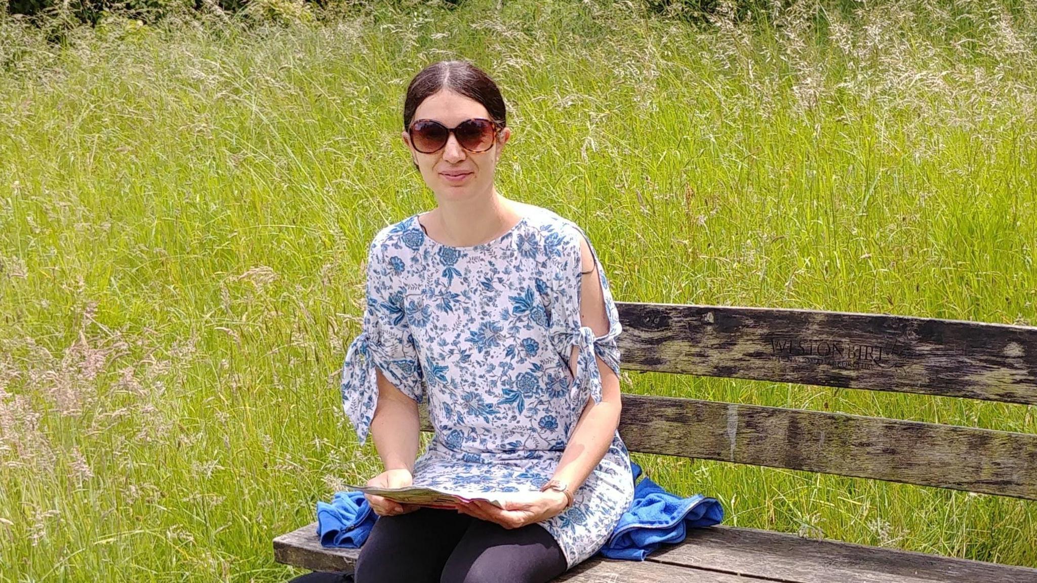 Caroline Mitchell sat at a bench with a book