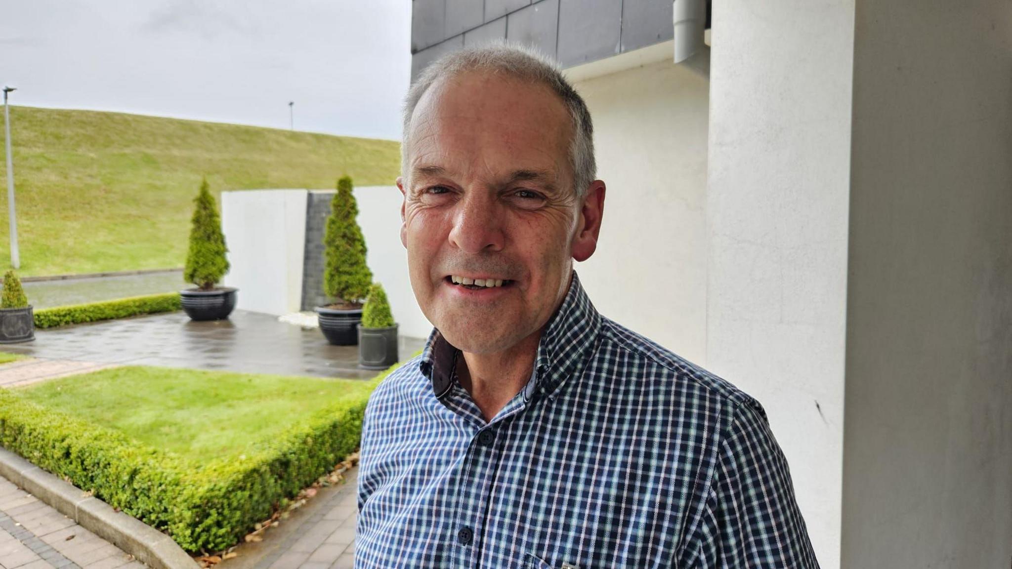 A close up image of Stuart Brooker, standing outdoors