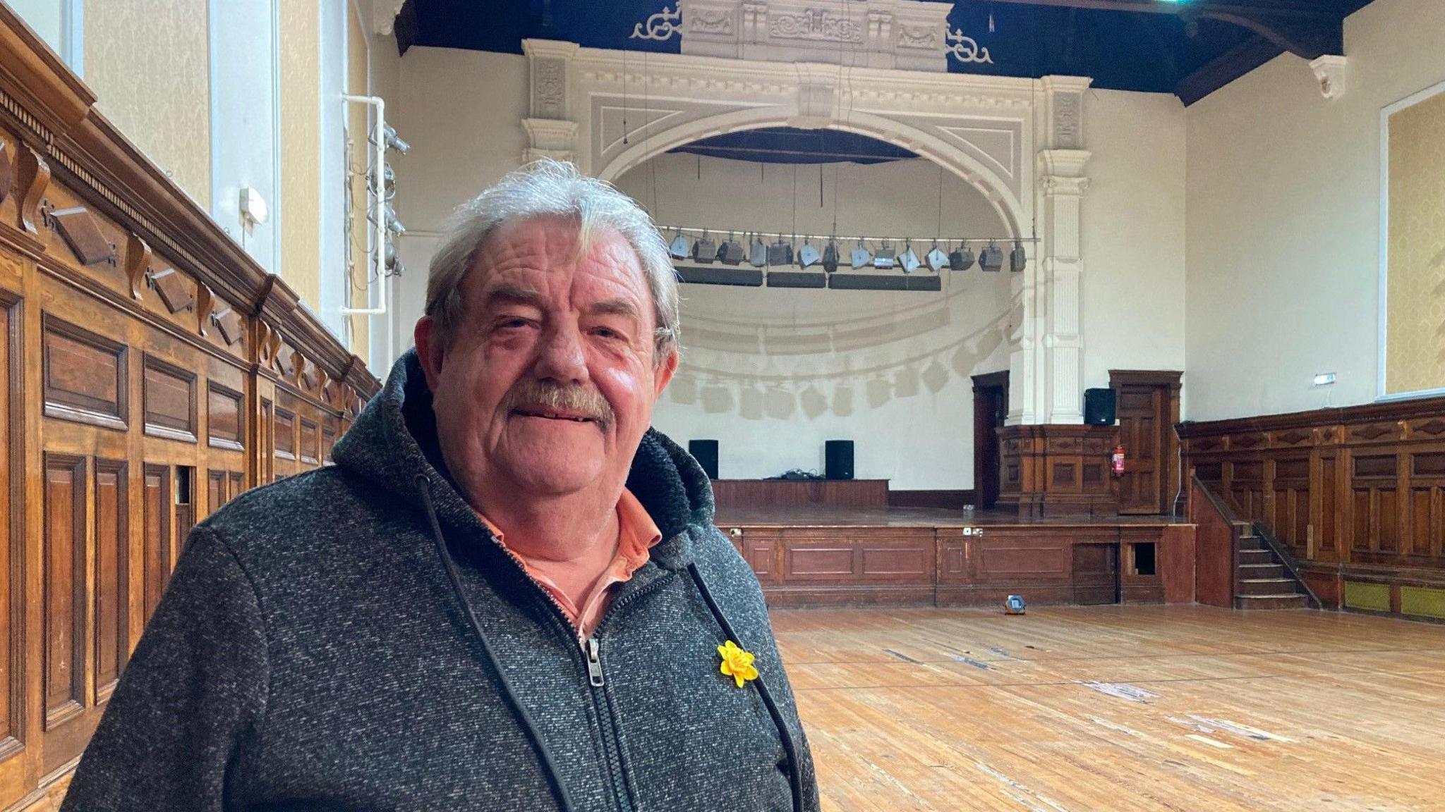 A man standing inside a concert hall