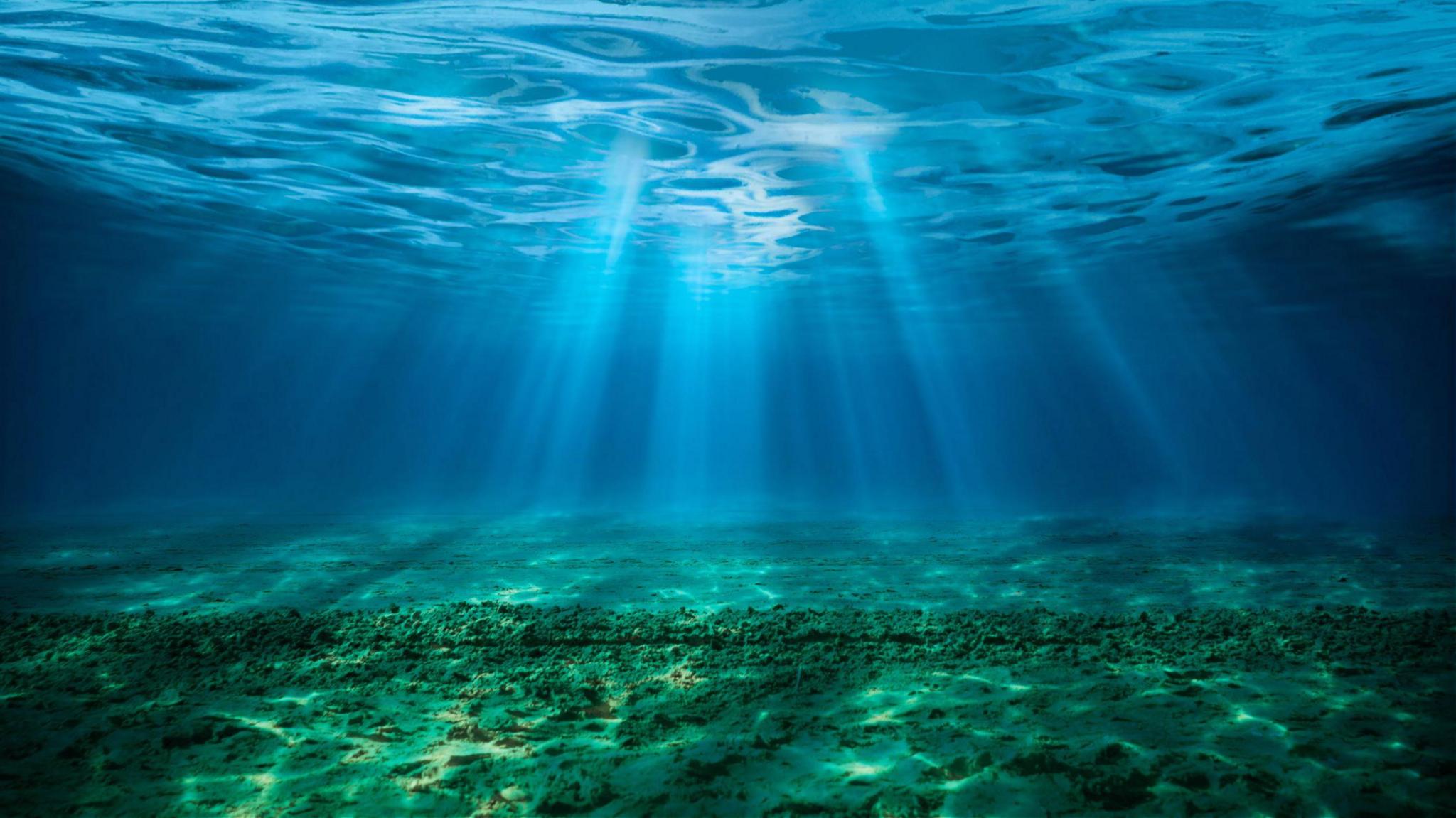 light refracting through ocean water showing the seabed