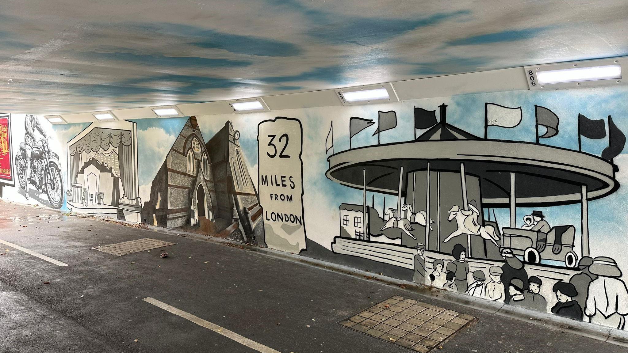 A picture of part of the mural, including a roundabout from the Charter Fayre and a sign saying its 32 miles from London.