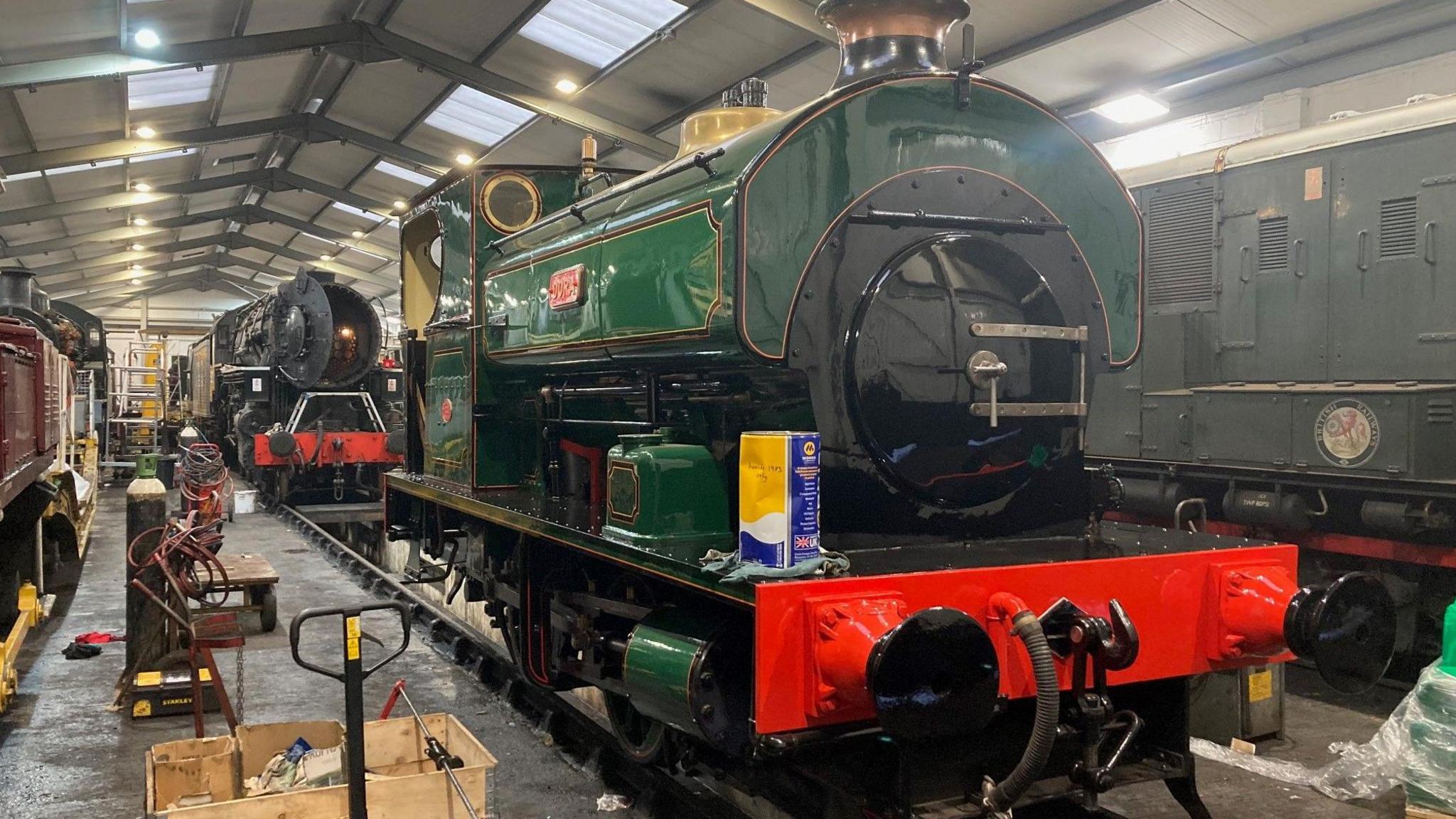 A green and black liveried locomotive inside one of the sheds at the Keighley and Worth Valley Railway's HQ in Haworth