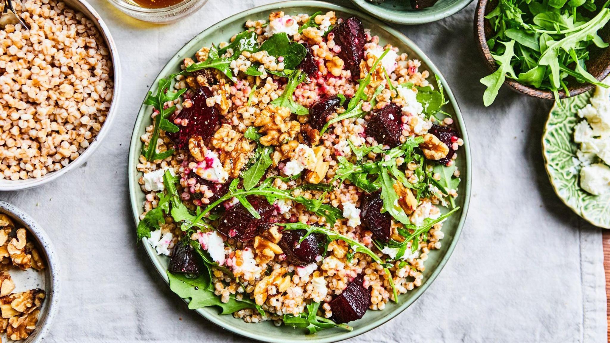 Dishes and bowls which contain certain grain based foods, with rocket salad and beetroot.