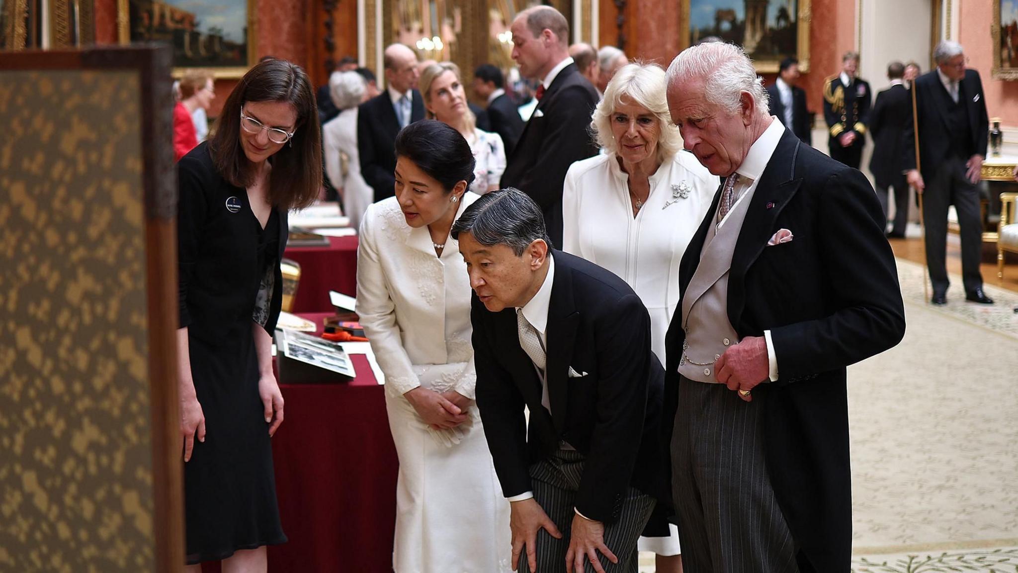 The Emperor and Empress of Japan looking at a piece of art with King Charles and Queen Camilla