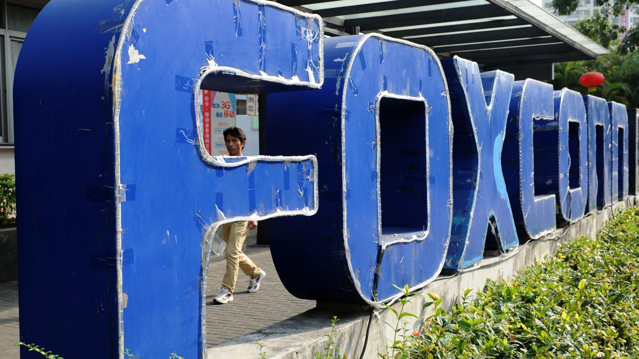 This picture taken on February 22, 2013 shows a young man walking past a Foxconn recruitment point in Shenzhen, south China's Guangdong province.