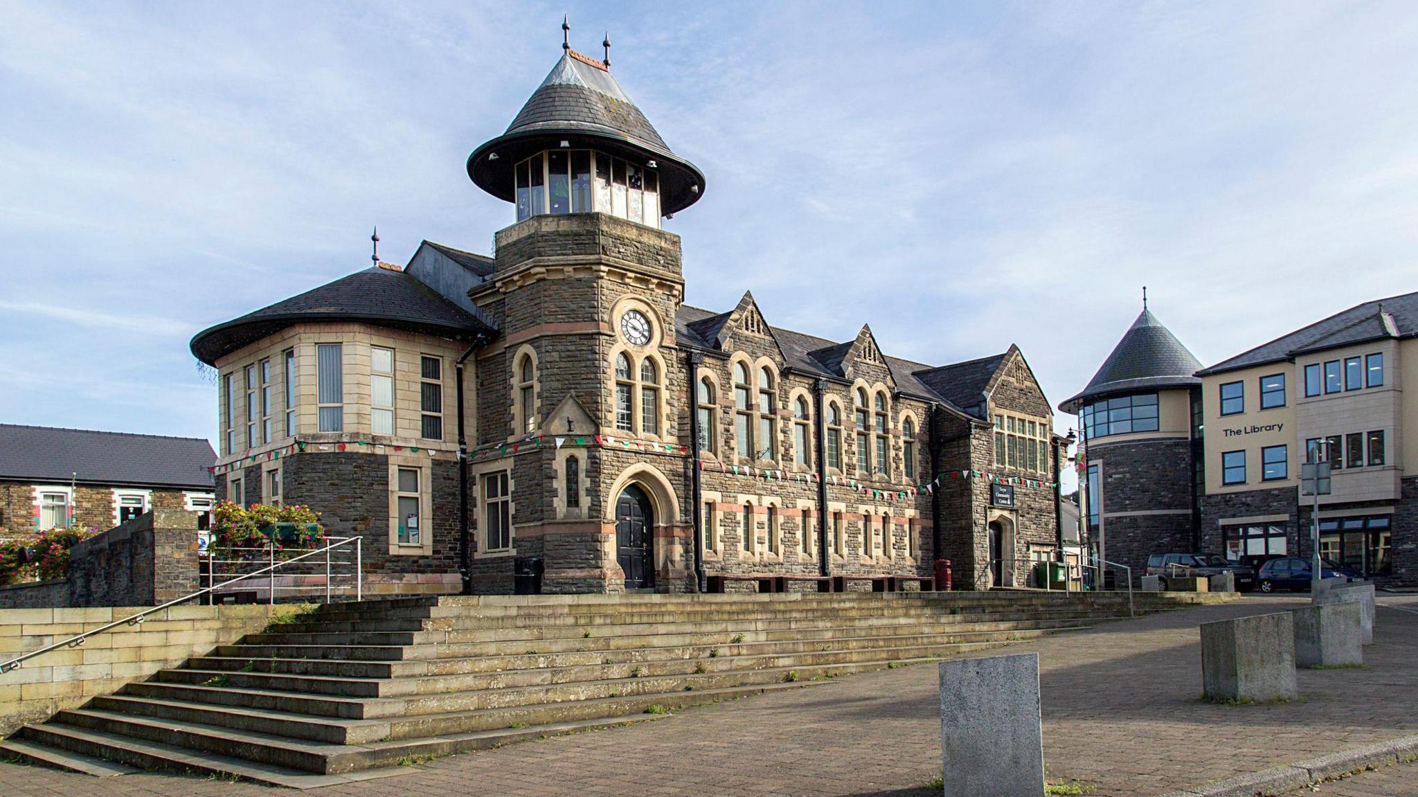 Caerphilly community centre in the town centre. There are stairs leading up to it and a library on the right.