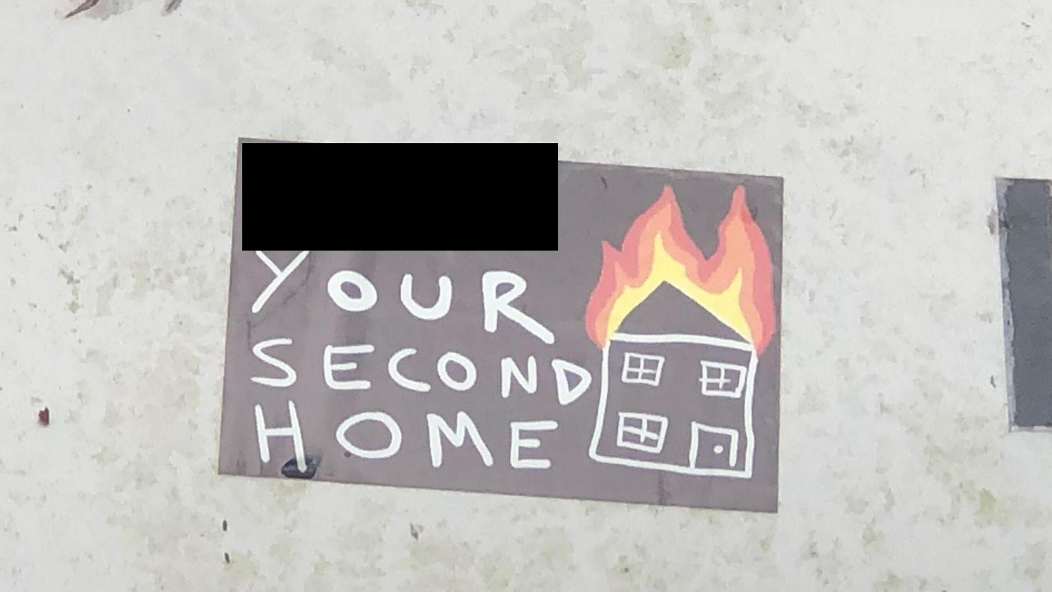 One of the stickers showing a burning house and a partly-covered wording