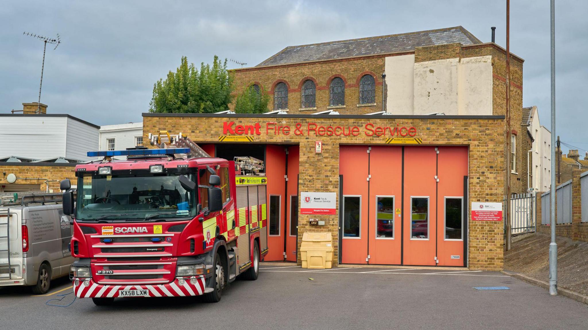 Kent Fire and Rescue Service building with orange doors, red fire truck in front