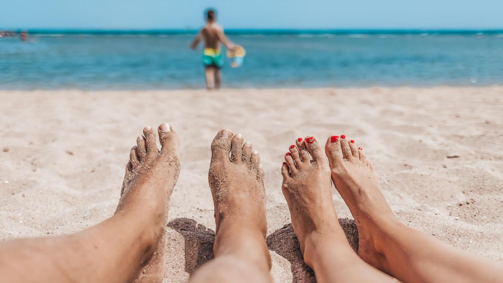 People lying on a beach in the sun