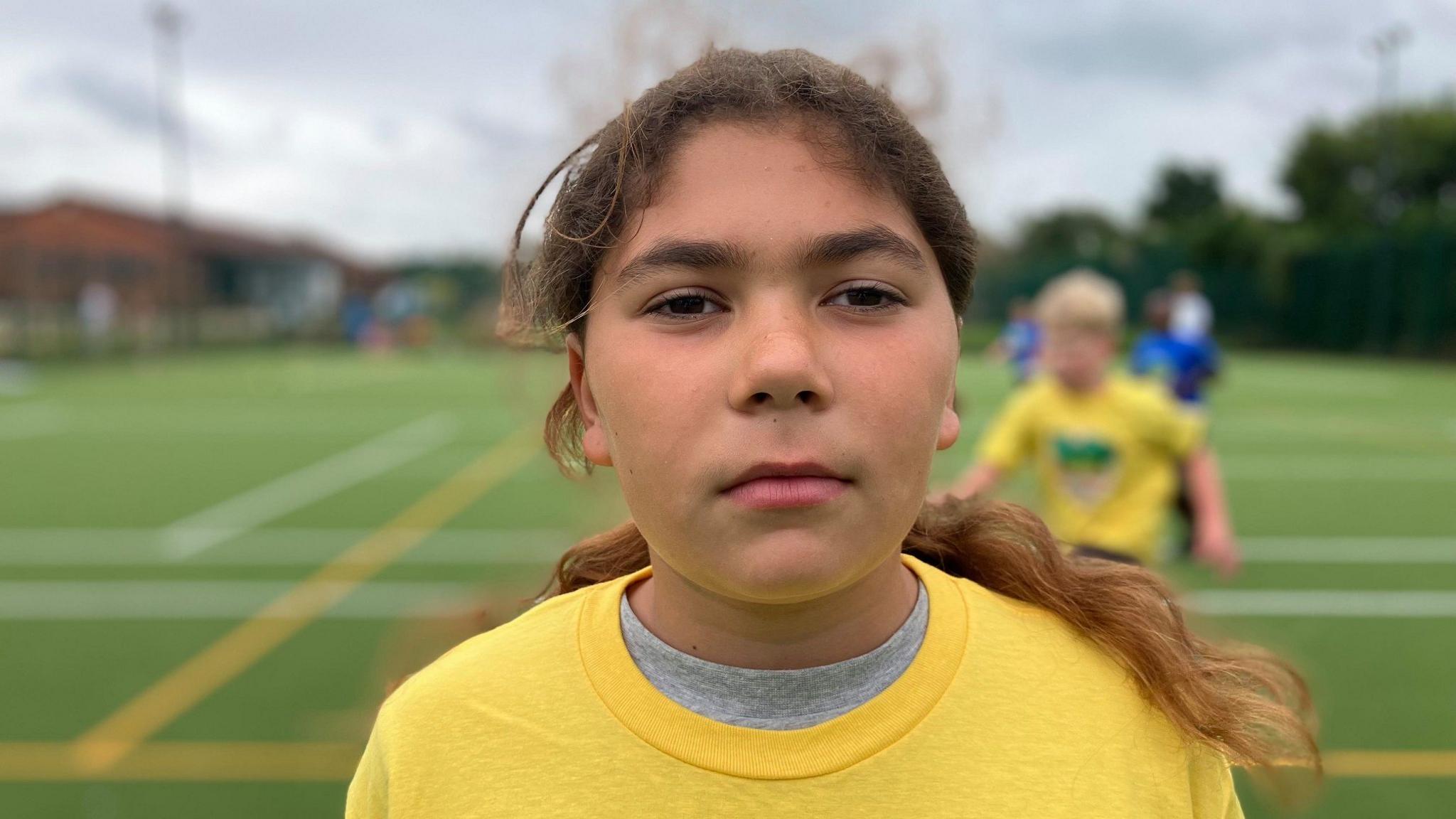 Girl in yellow t shirt on sports field