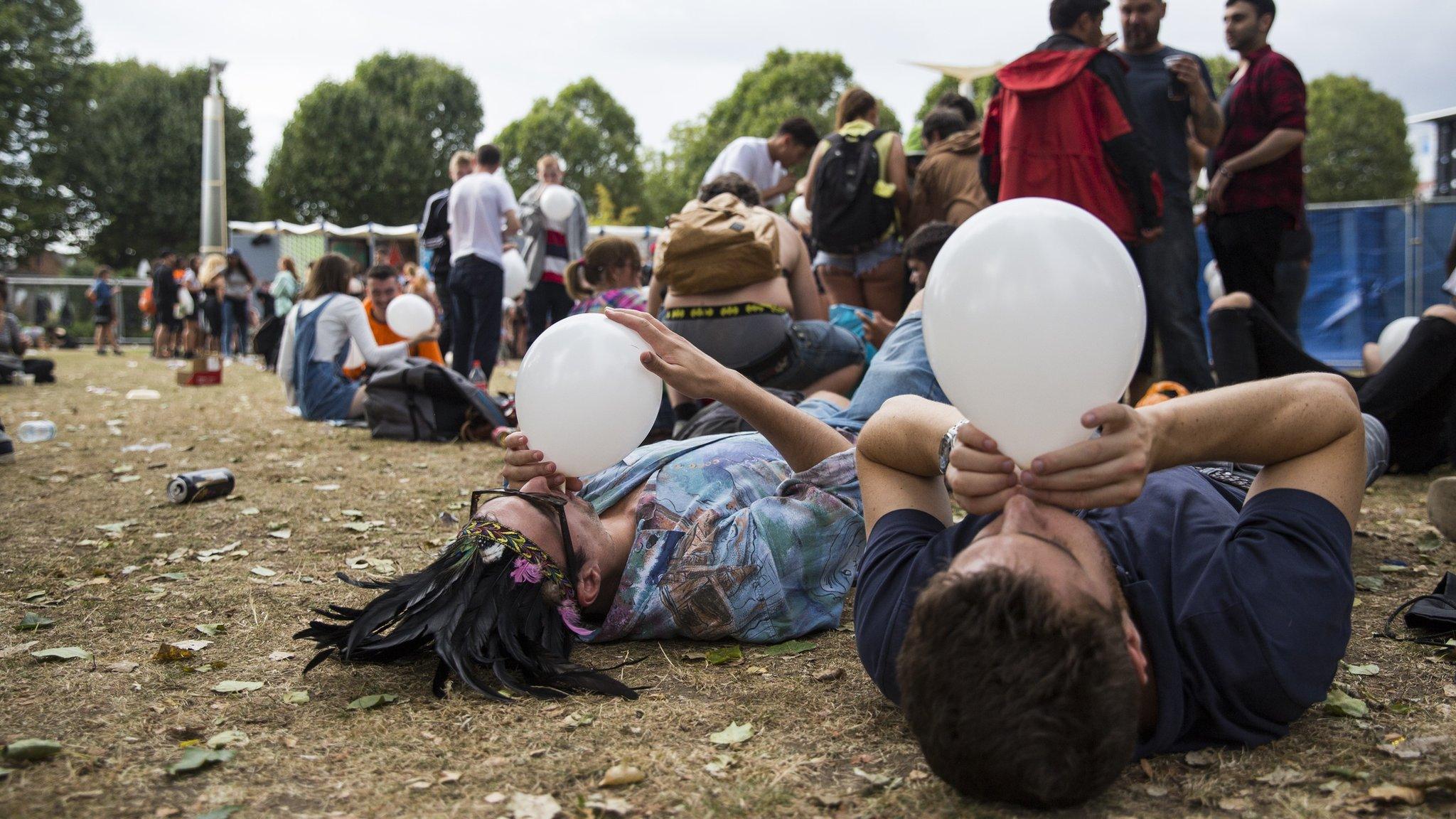 Revellers inhale nitrous oxide from balloons