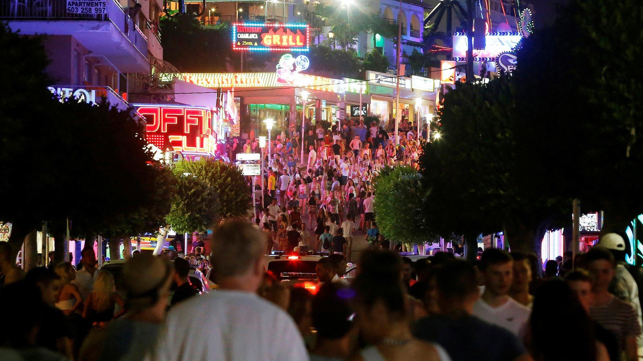 Tourists walk along Punta Ballena street in Magaluf, on the Spanish Balearic island of Mallorca, 25 July, 2014.