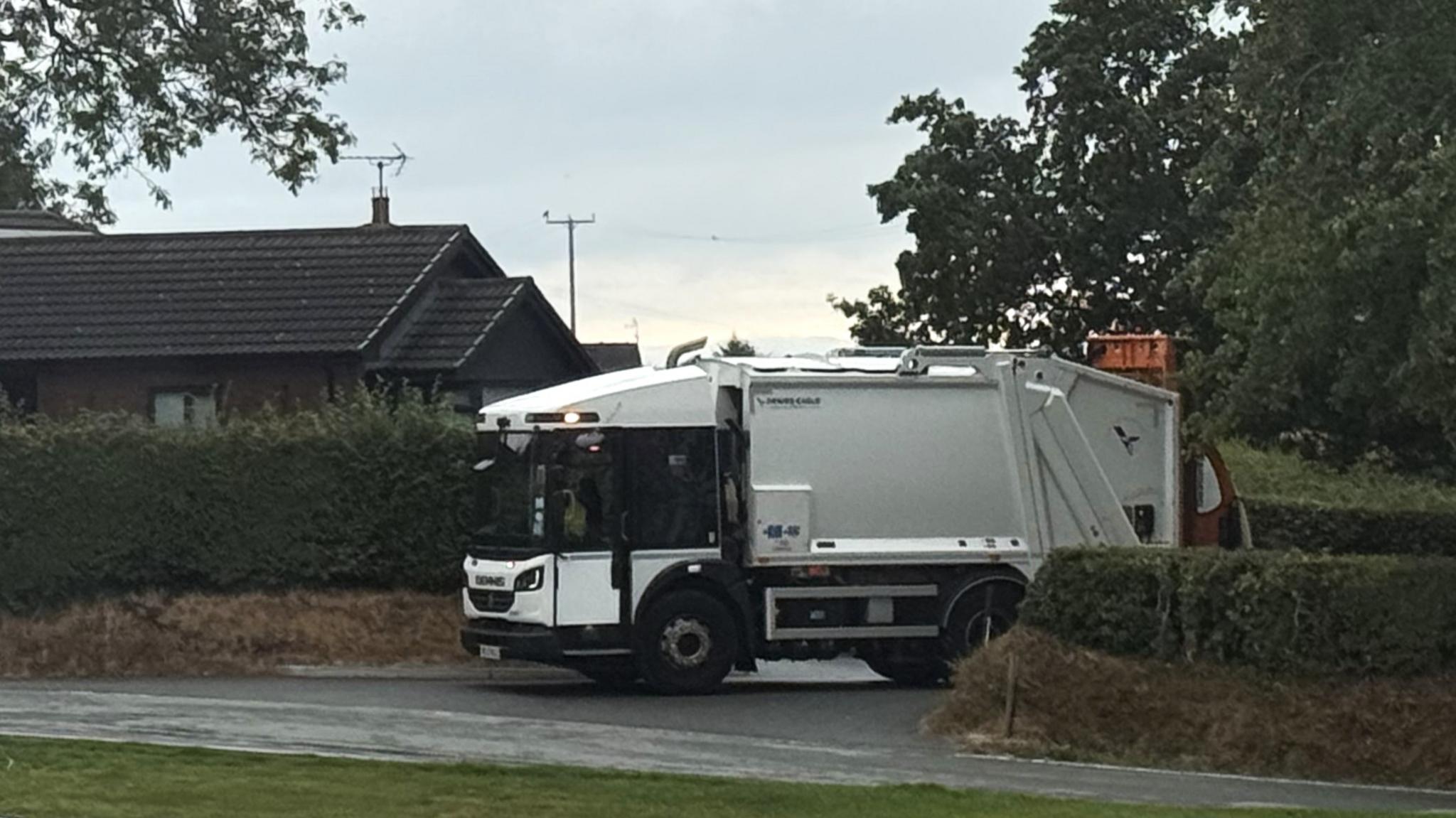 A bin lorry pulling out of the junction opposite Castle Green's Hawthorn Meadows development in Buckley -
