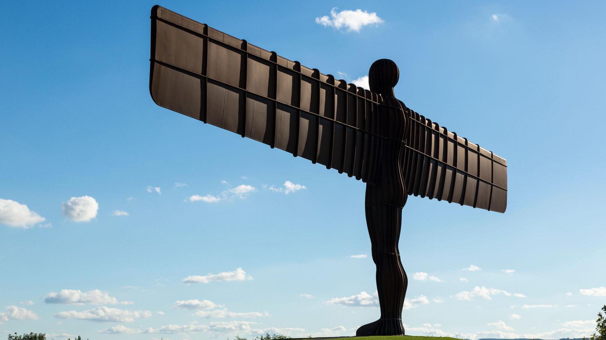 Angel of the north stands with a blue sky with few clouds