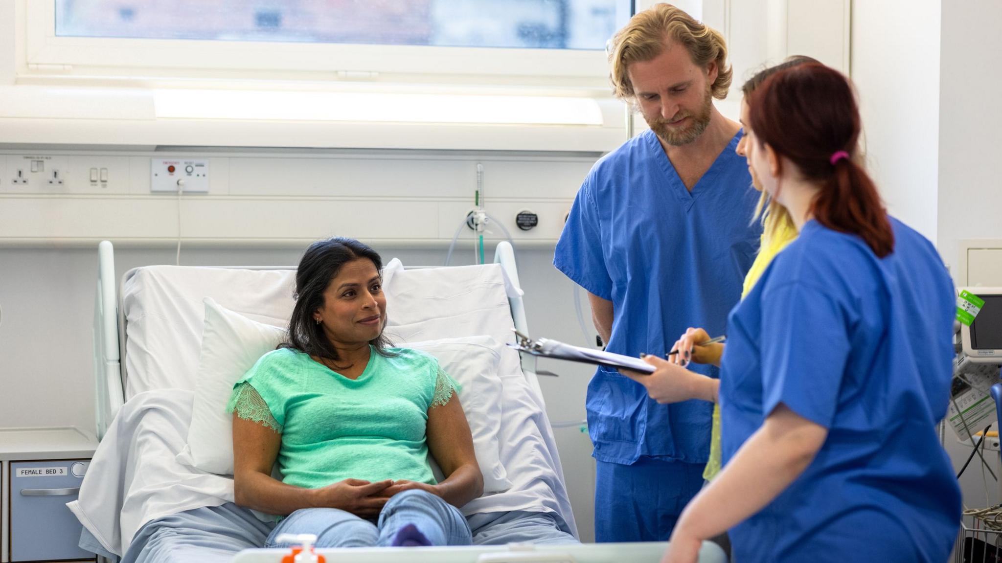 Health workers talking to a patient 