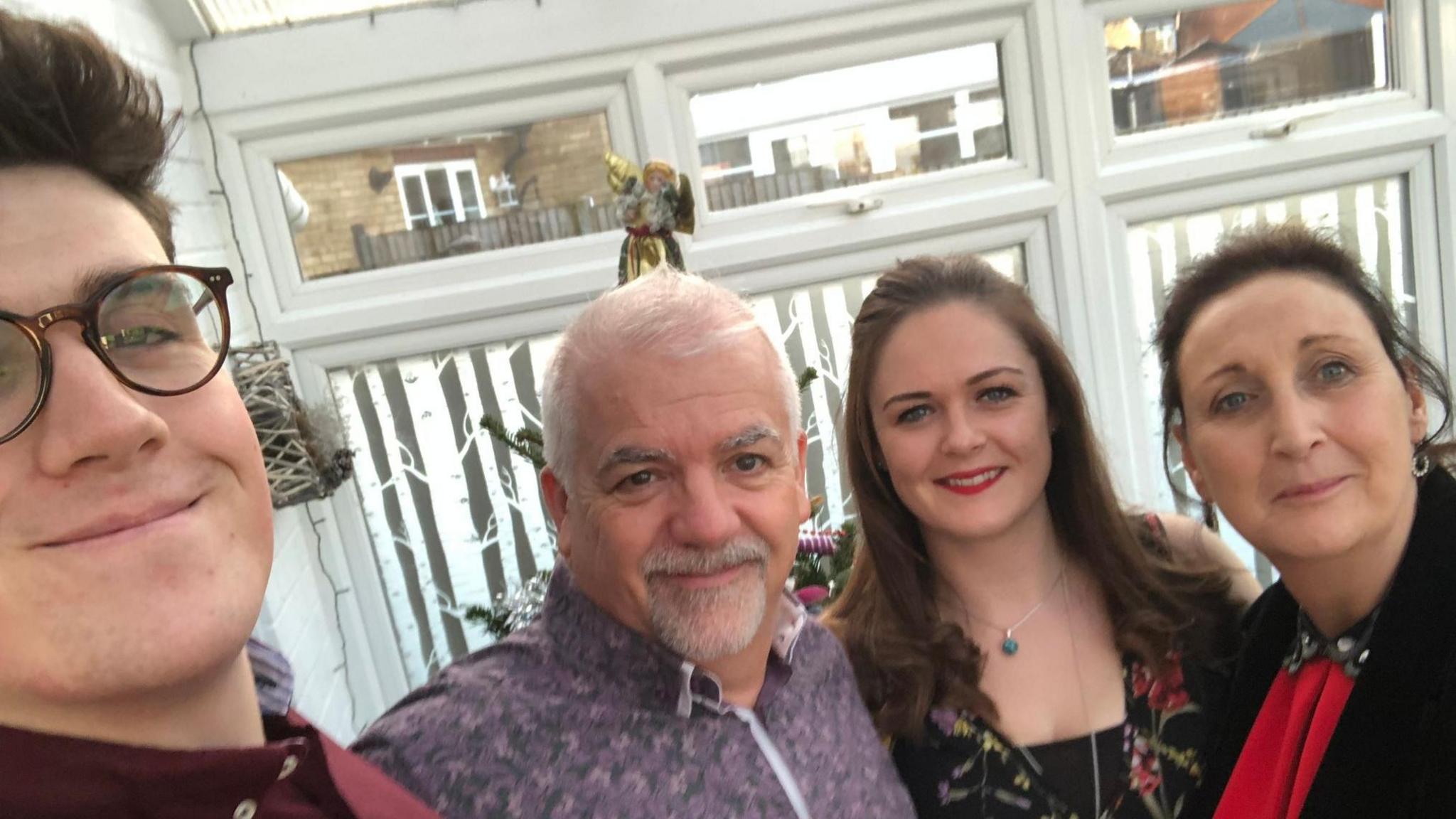 A group of people all smiling at the camera. There are two women and two men 