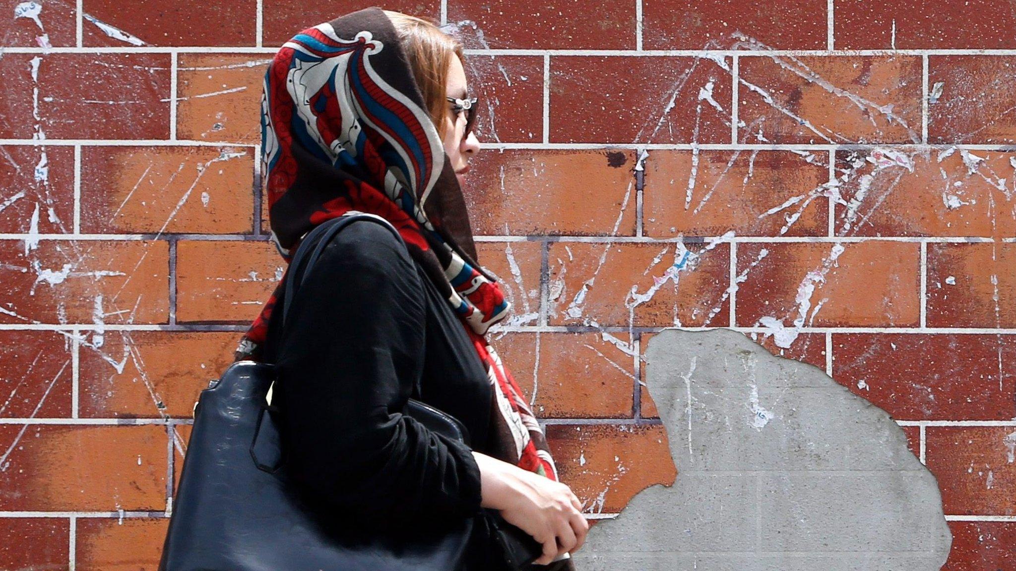 A woman walks down a street in Tehran, Iran (28 April 2016)