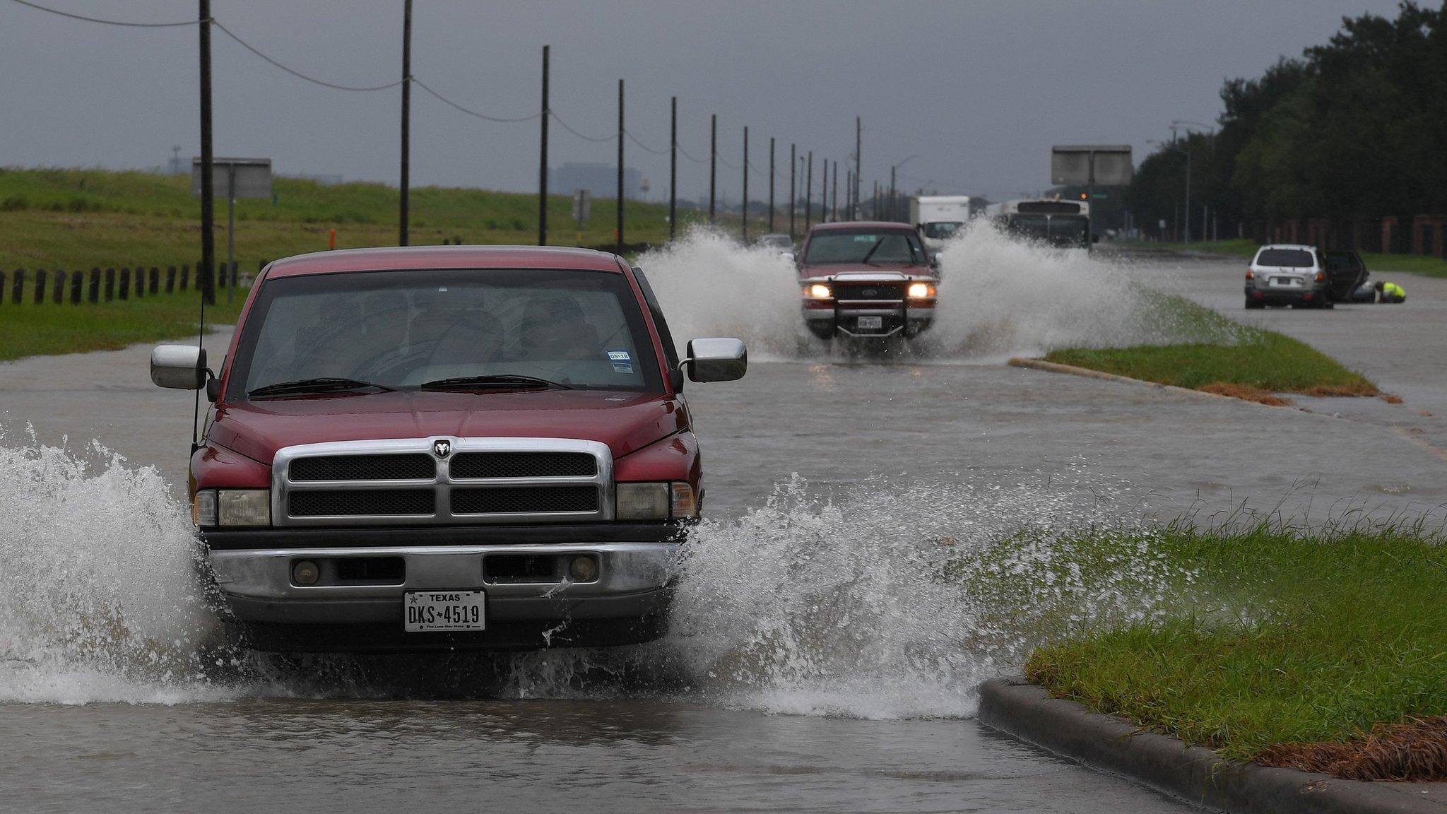 ehicles drive along a flooded road beside the Barker Reservoir after the Army Corp of Engineers started to release water into the Clodine district as Hurricane Harvey caused heavy flooding in Houston, Texas on August 29, 2017