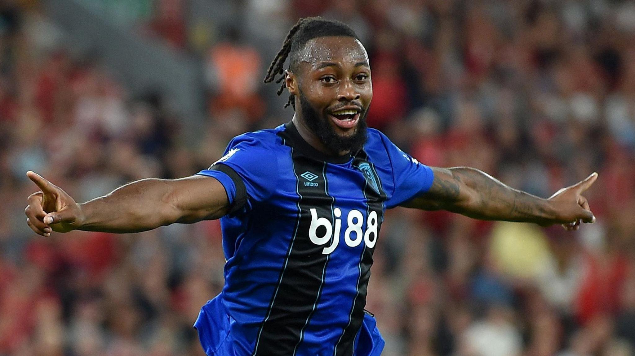 Semenyo celebrating after scoring for Bournemouth. He had short dreadlocked hair and a dark brown beard. He was wearing his dark blue and black Bournemouth away kit.