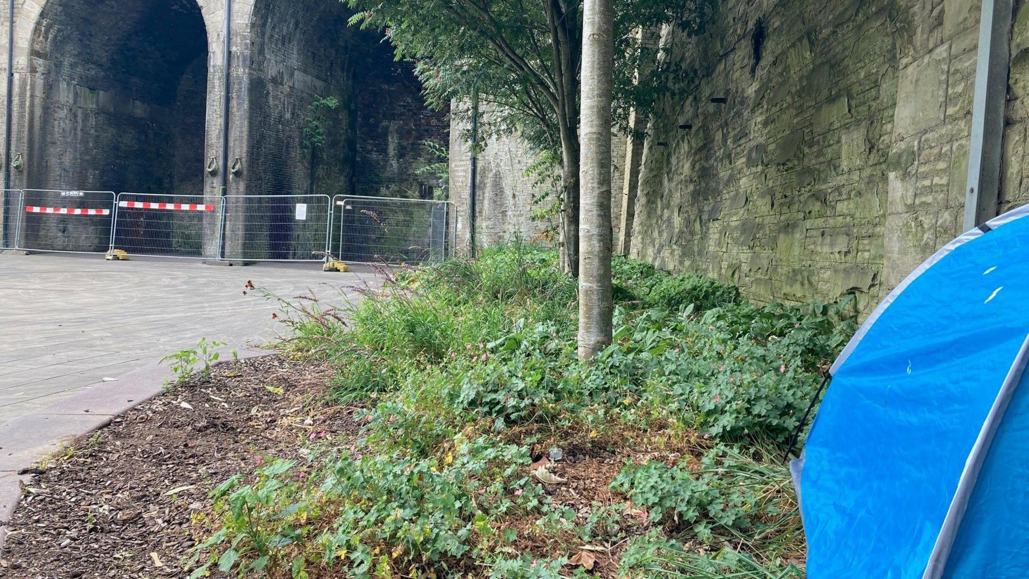 A blue tent pitched just yards away from the fenced off archways