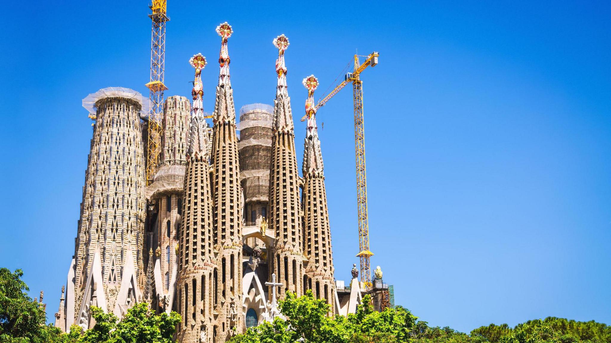 Sagrada Família seen from the ground with clear blue sky behind it