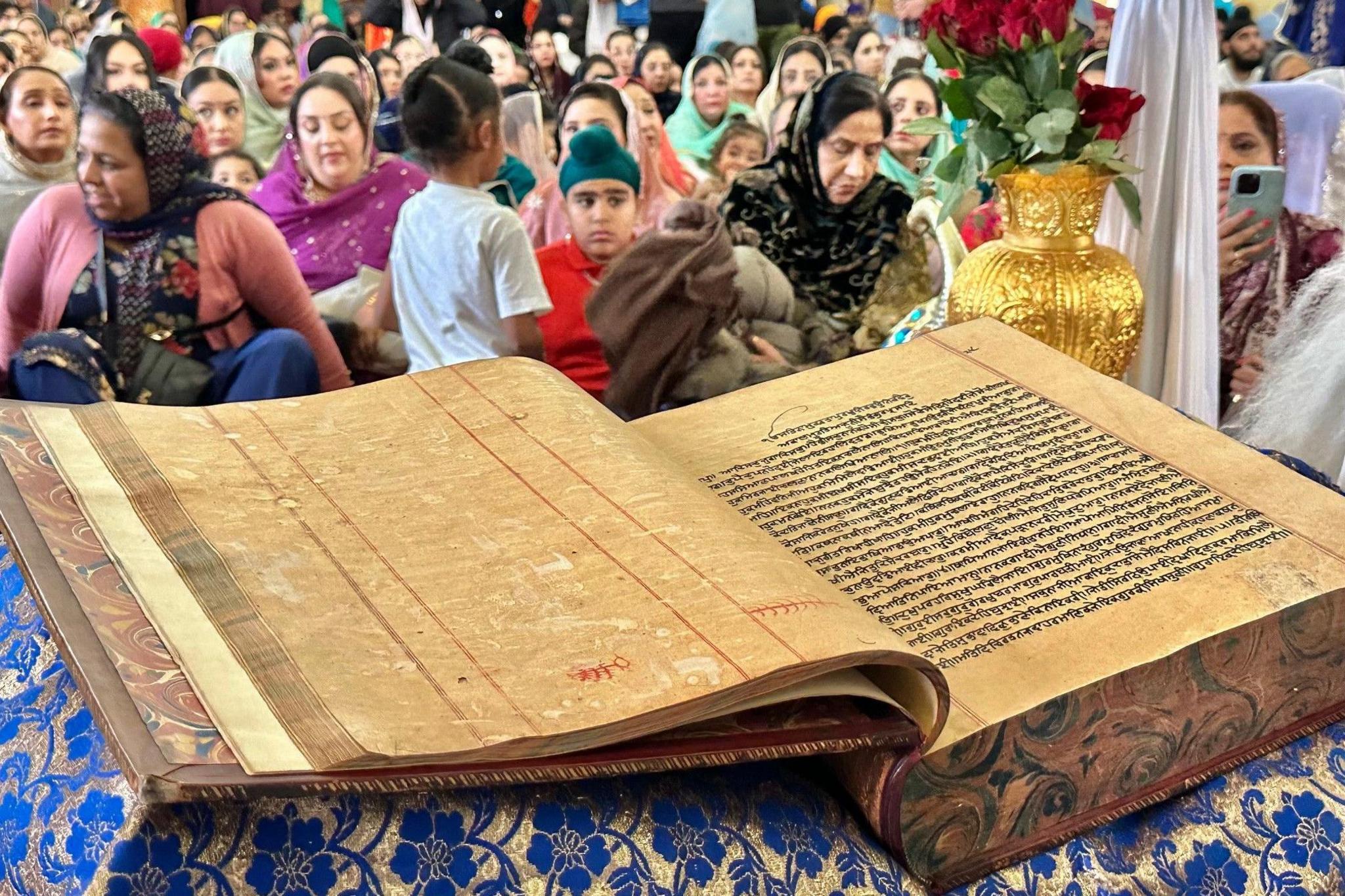 In the foreground is the book. In the background is crowds of people.