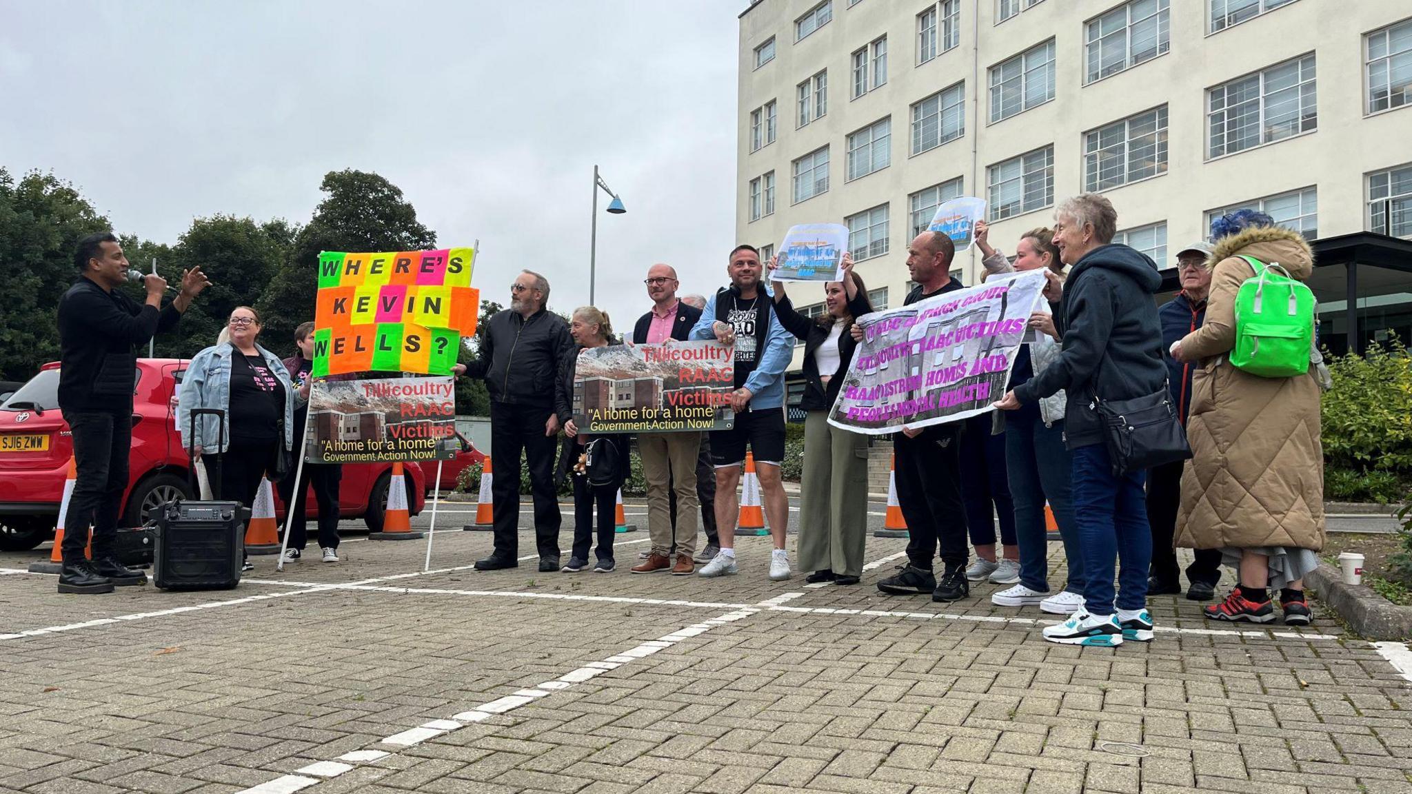 Group of protestors carrying banners, standing outside Clackmannanshire Council building