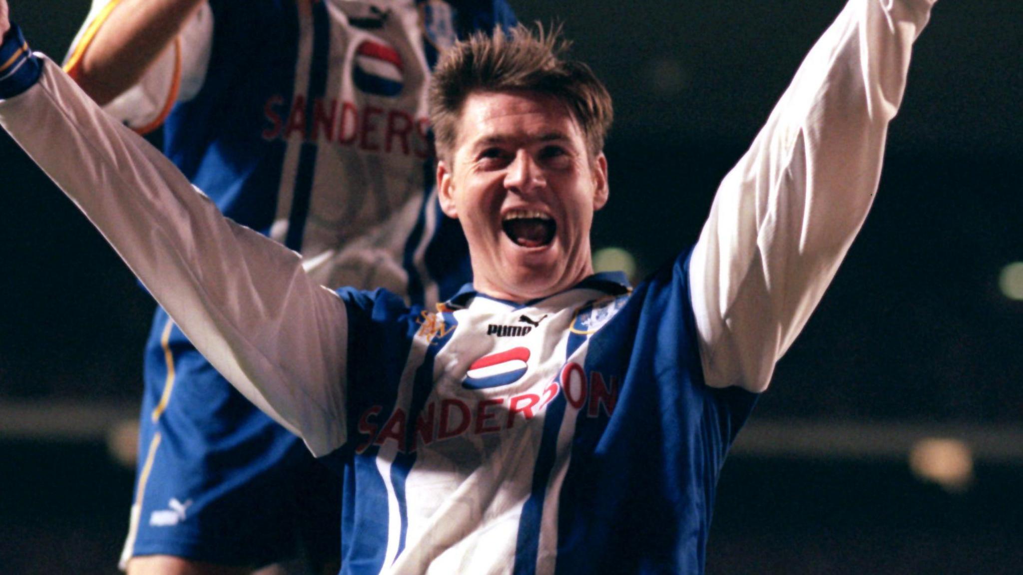 A photo of Chris Waddle, wearing his blue and white striped Sheffield Wednesday kit, celebrating his goal with his team-mate during their game against Arsenal in November 1995